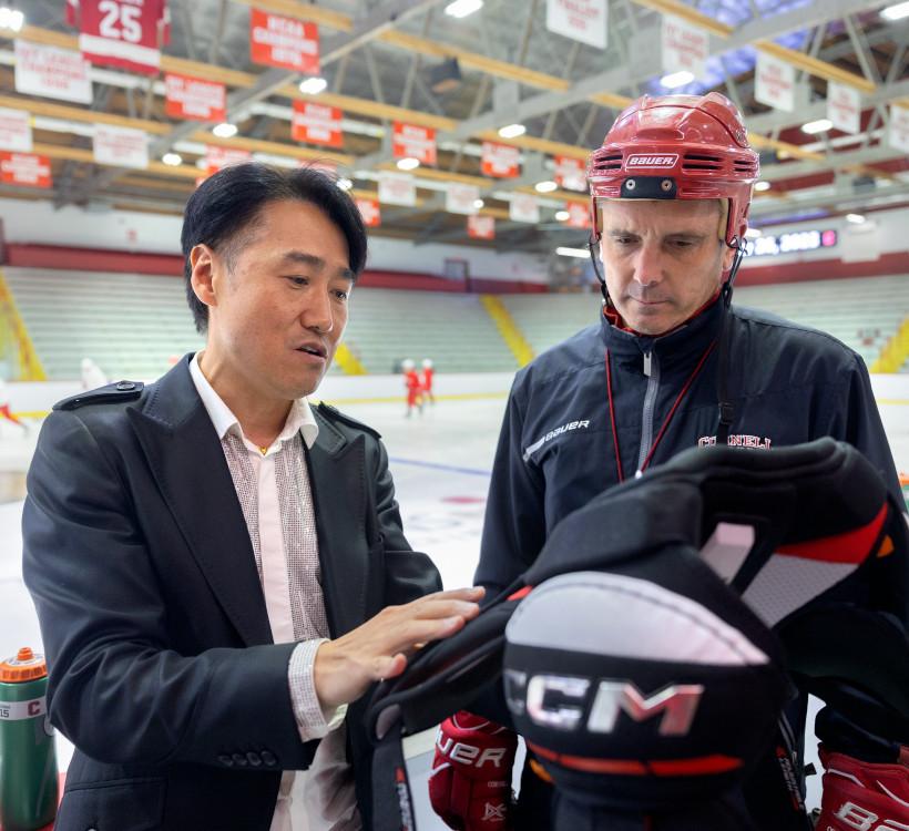 two people looking at protective gear in a hockey rink