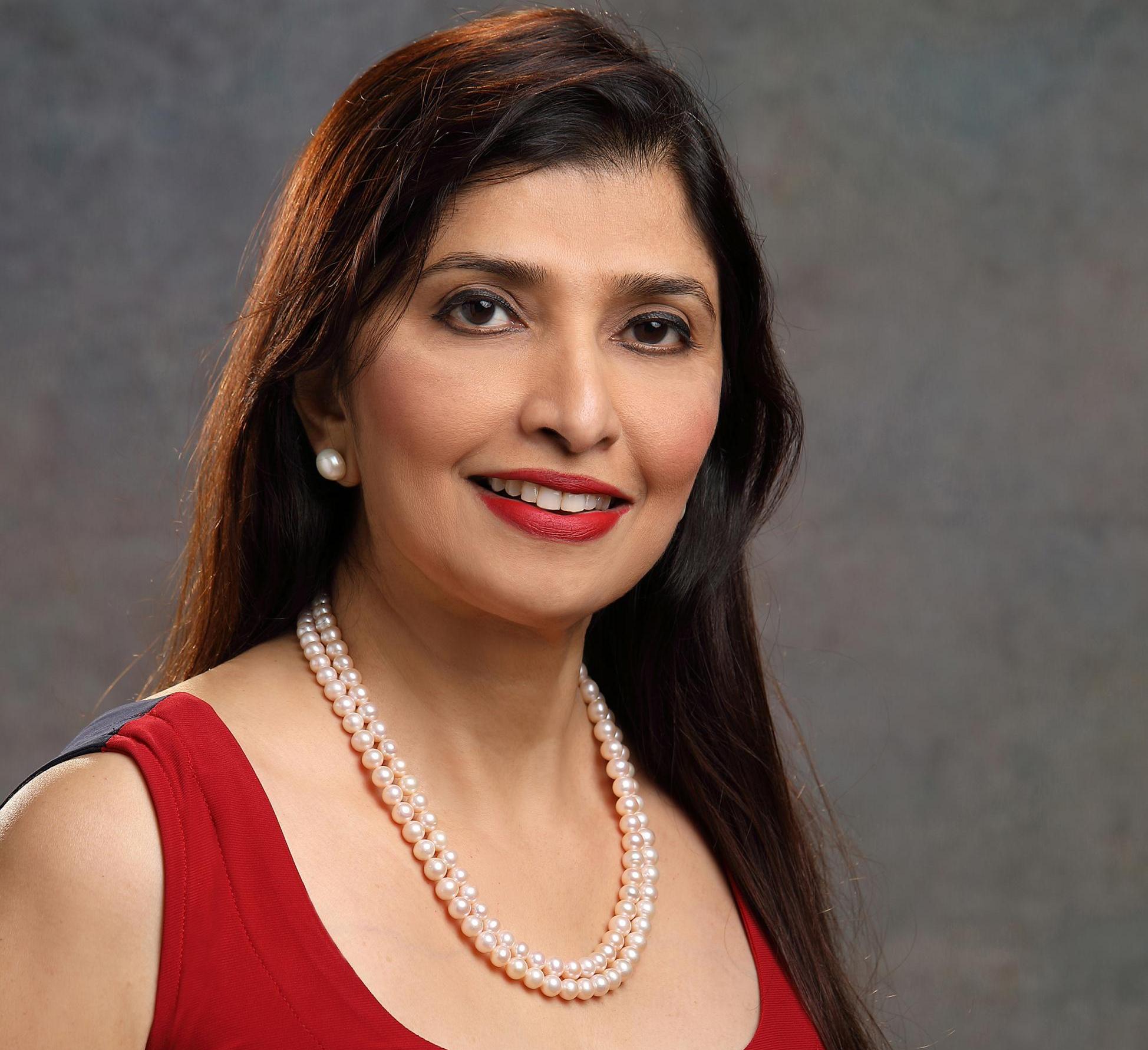 portrait of a woman in a red top and pearl necklace