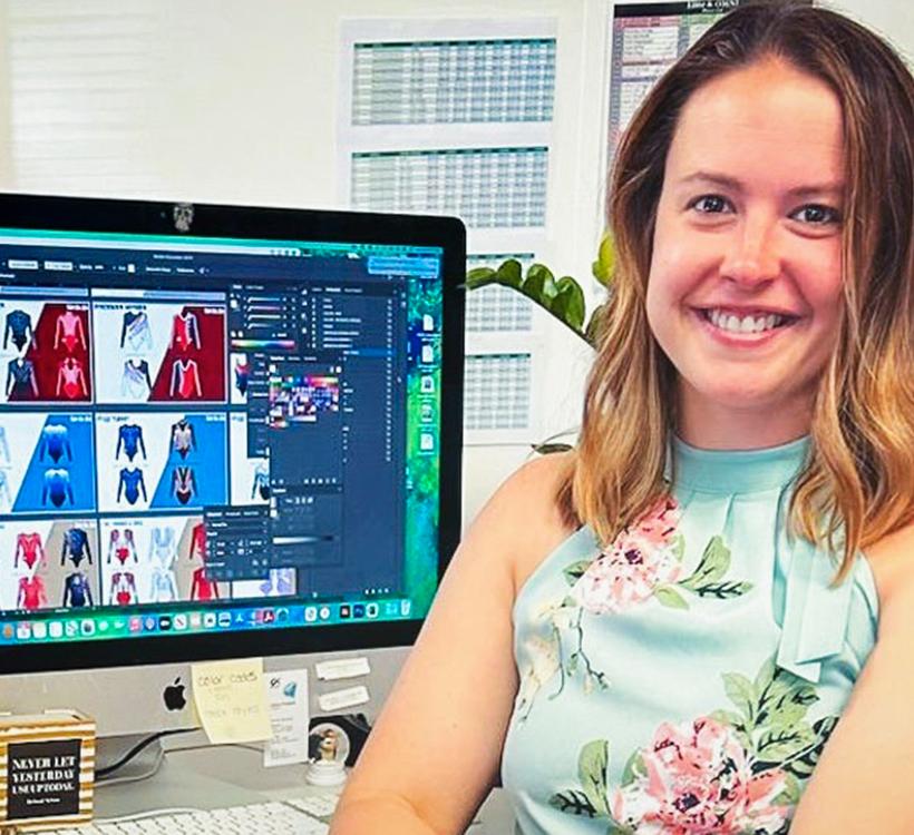 Jeanne Douglass Diaz ’10 sits at her desk in the offices of GK Elite Sportswear.