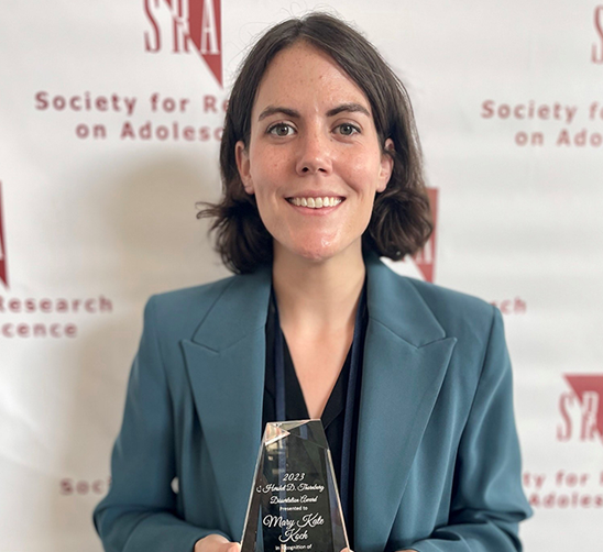 Mary Kate Koch Ph.D. ’22 smiling and holding the Hershel D. Thornburg Dissertation Award