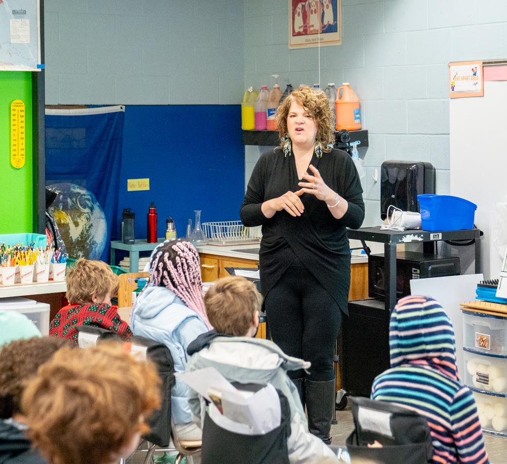 woman standing in front of a fourth grade classroom
