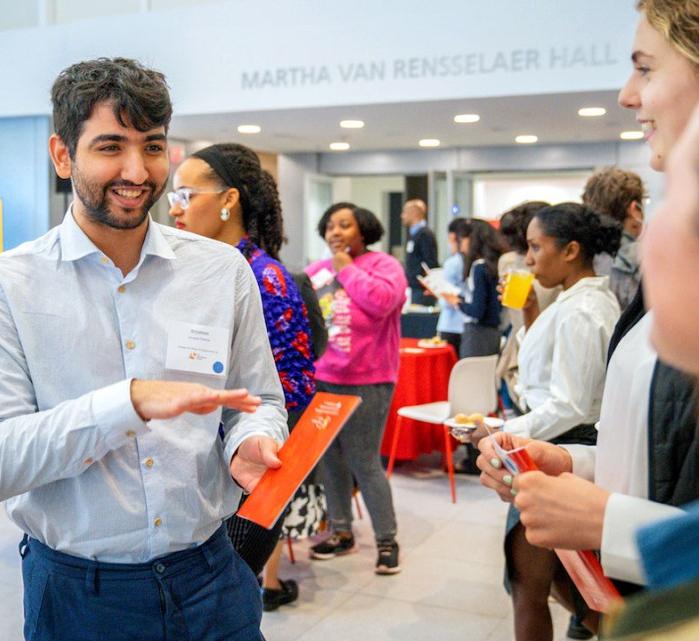 A student explains his project to peers