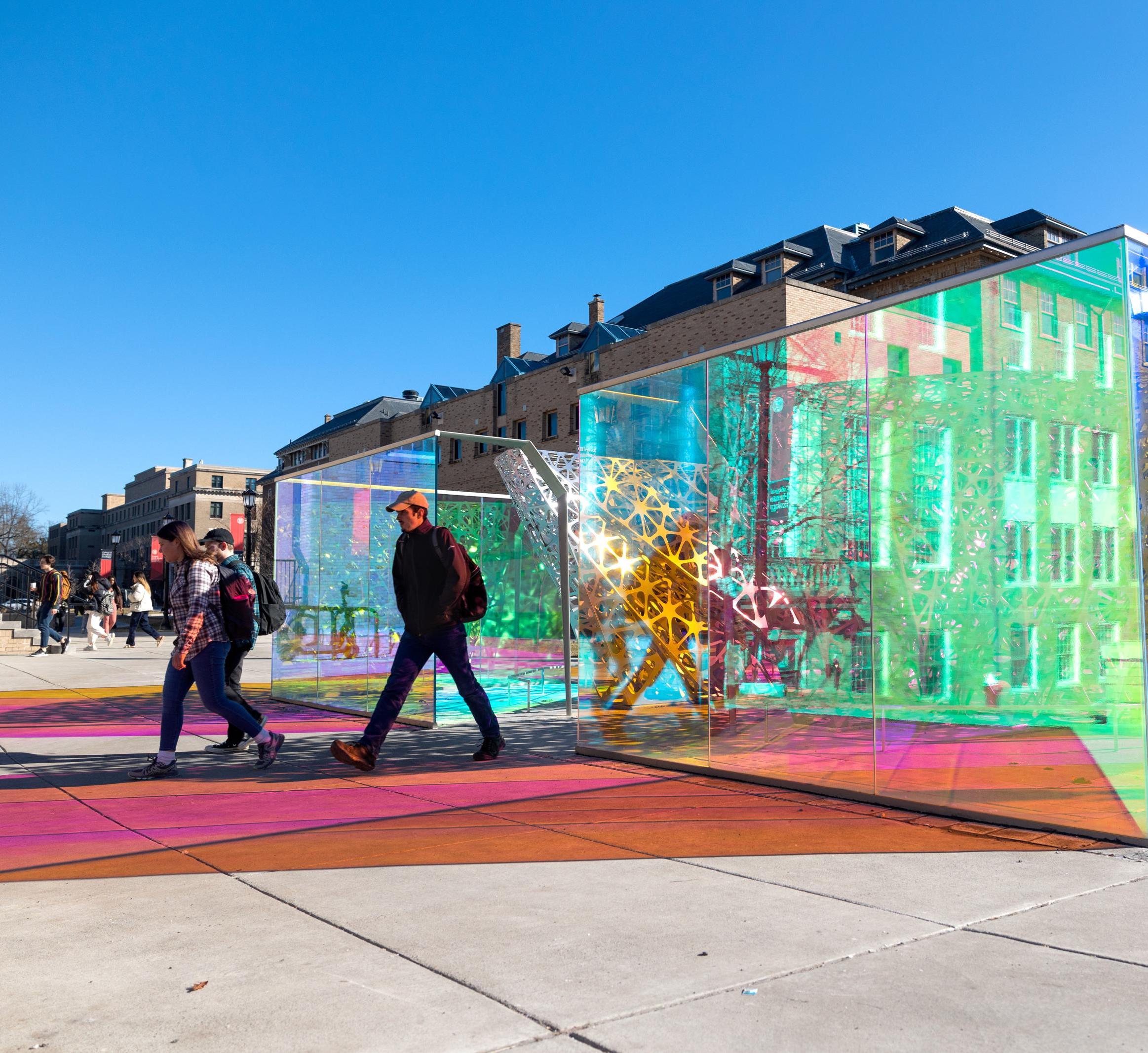 a faculty member walks past the polyform sculpture