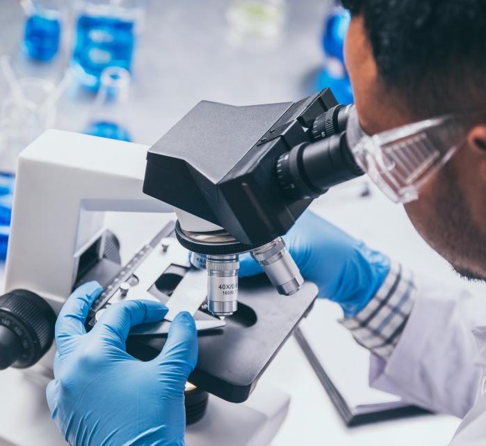 Image of a male-presenting person looking in a microscope