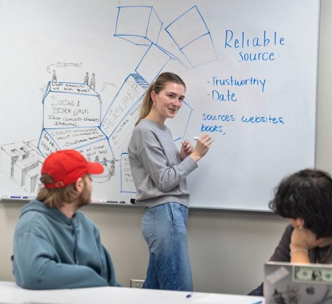 A student explains plans to two others 