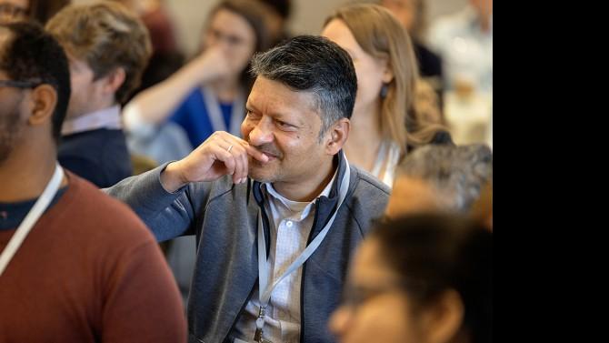 An audience member listens as a panel of Cornell leaders speaks during the Inclusive Excellence Summit in the Statler Ballroom.