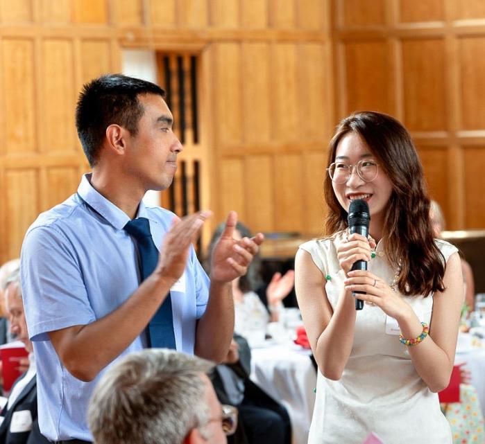 Two students and a faculty member stand together and present at the Merrill Scholar reception