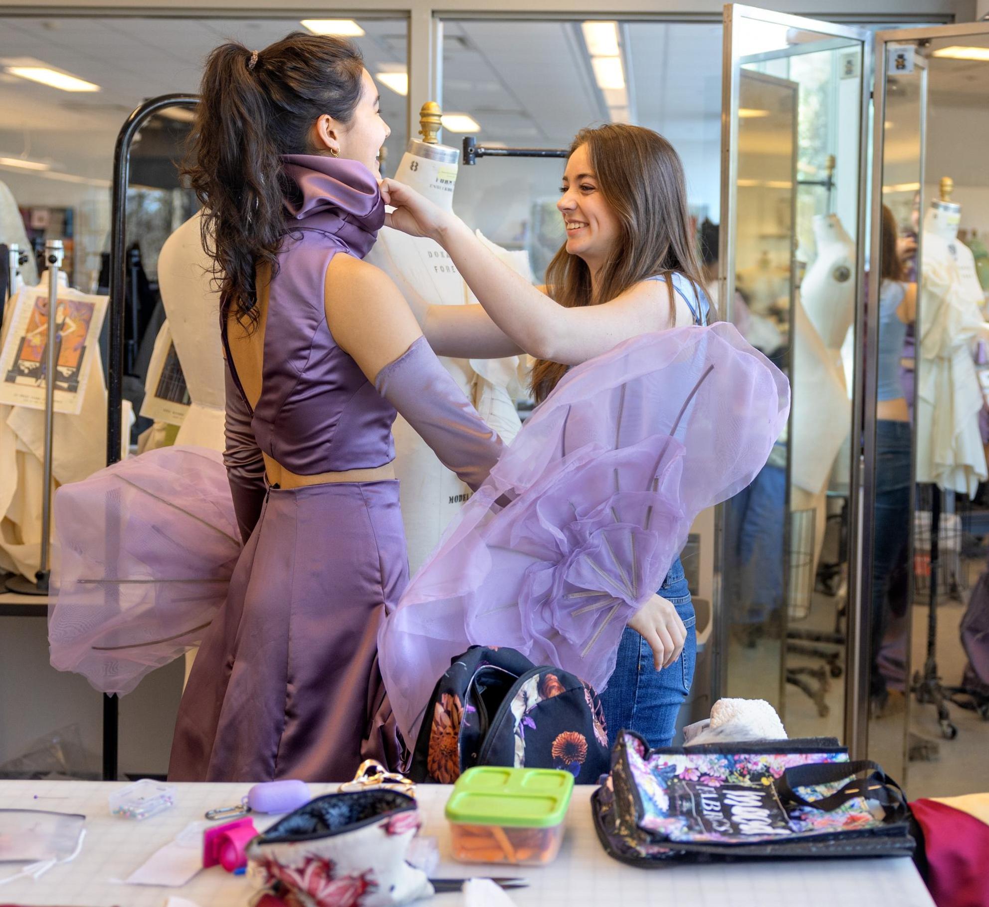 Designer Margaret Watkins fits a model 