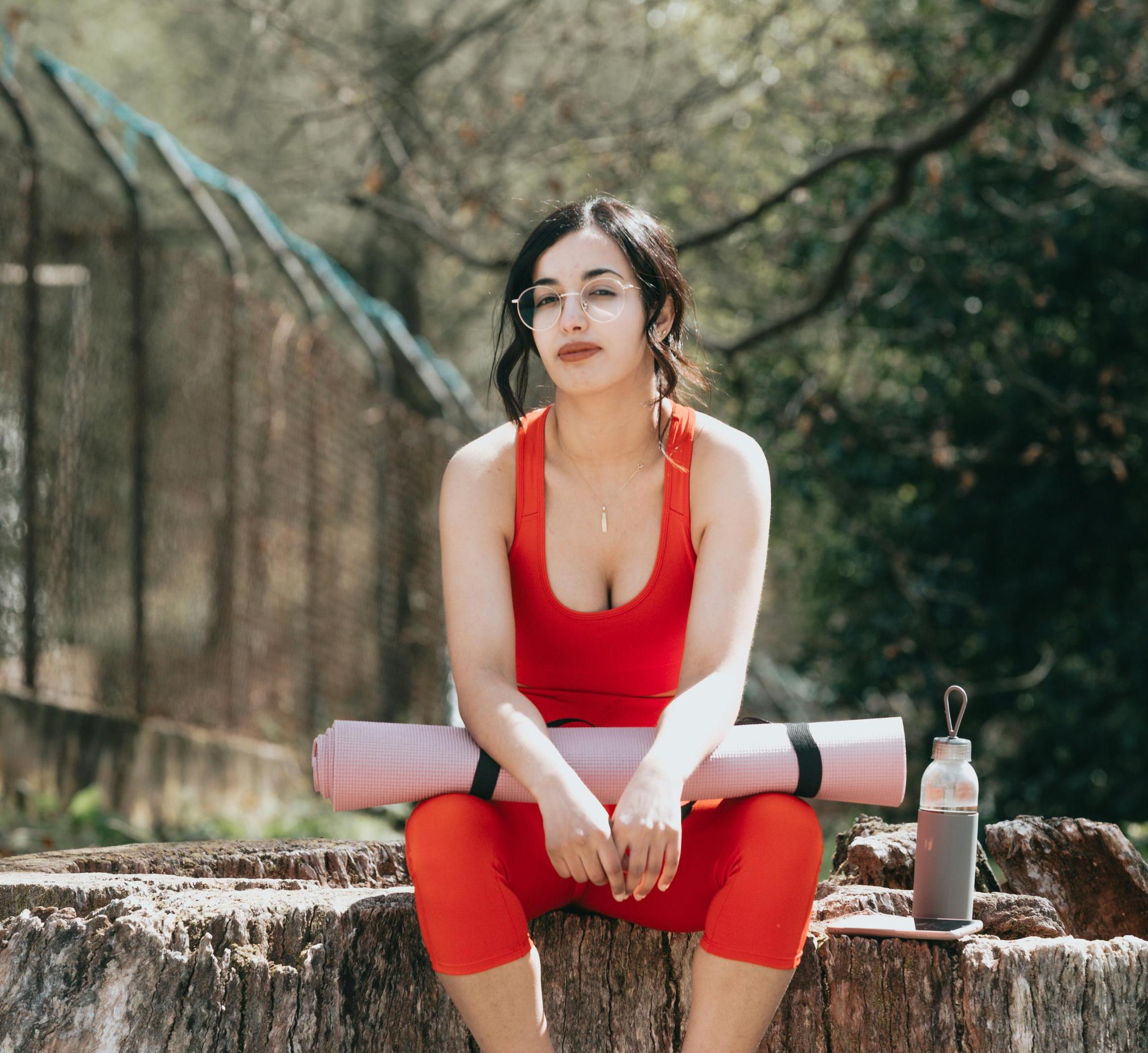 woman sitting with a yoga mat