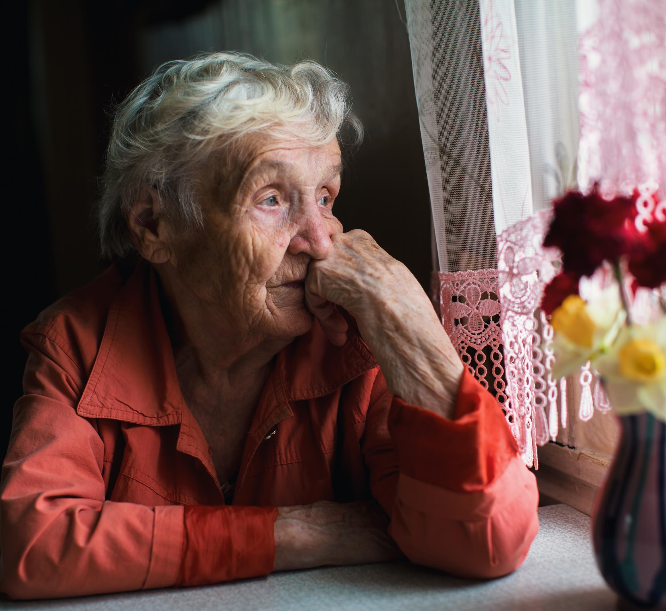 Older woman looks out the window