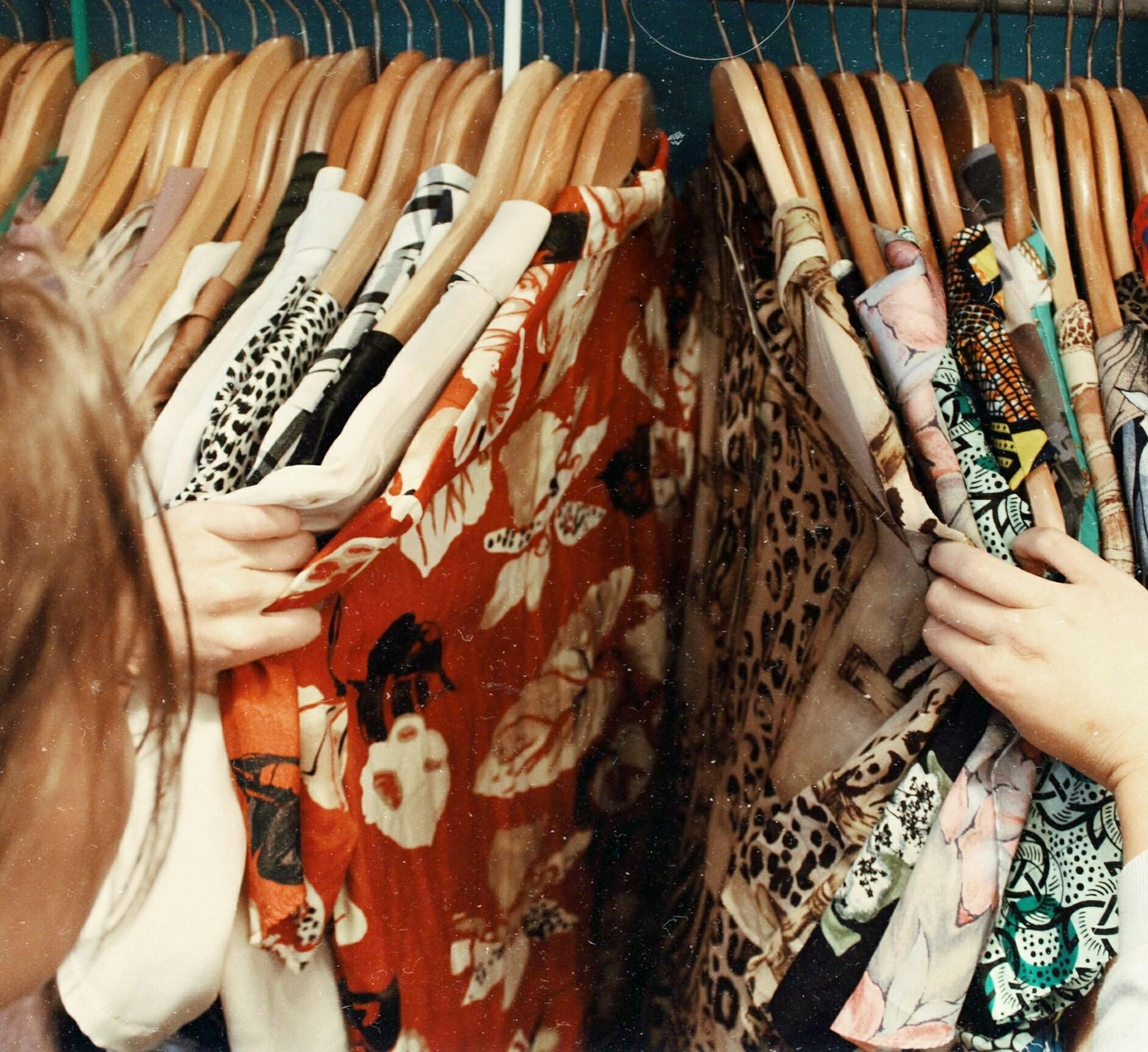 A girl looks at dresses at the thrift store 