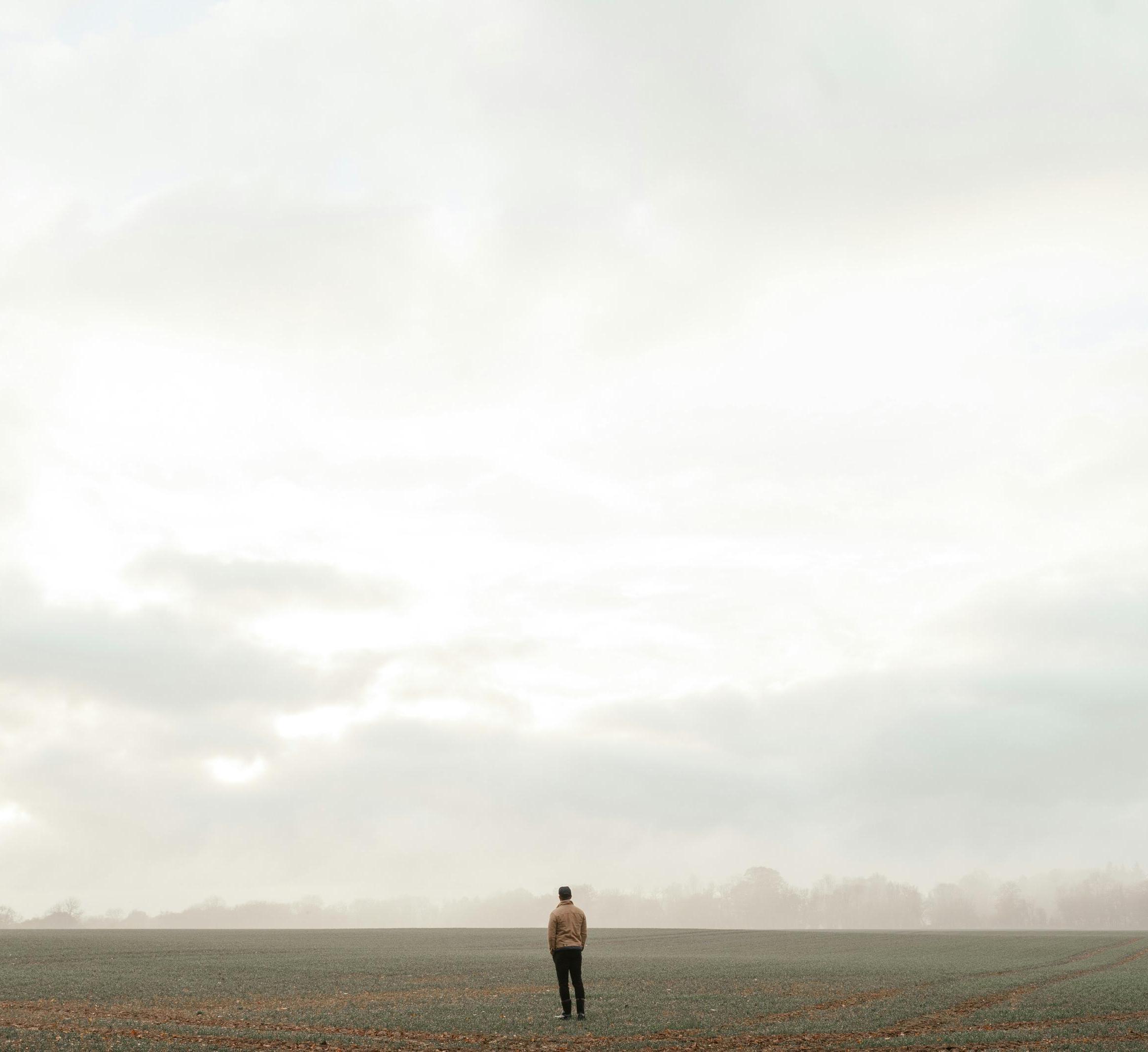 person standing alone in a field 