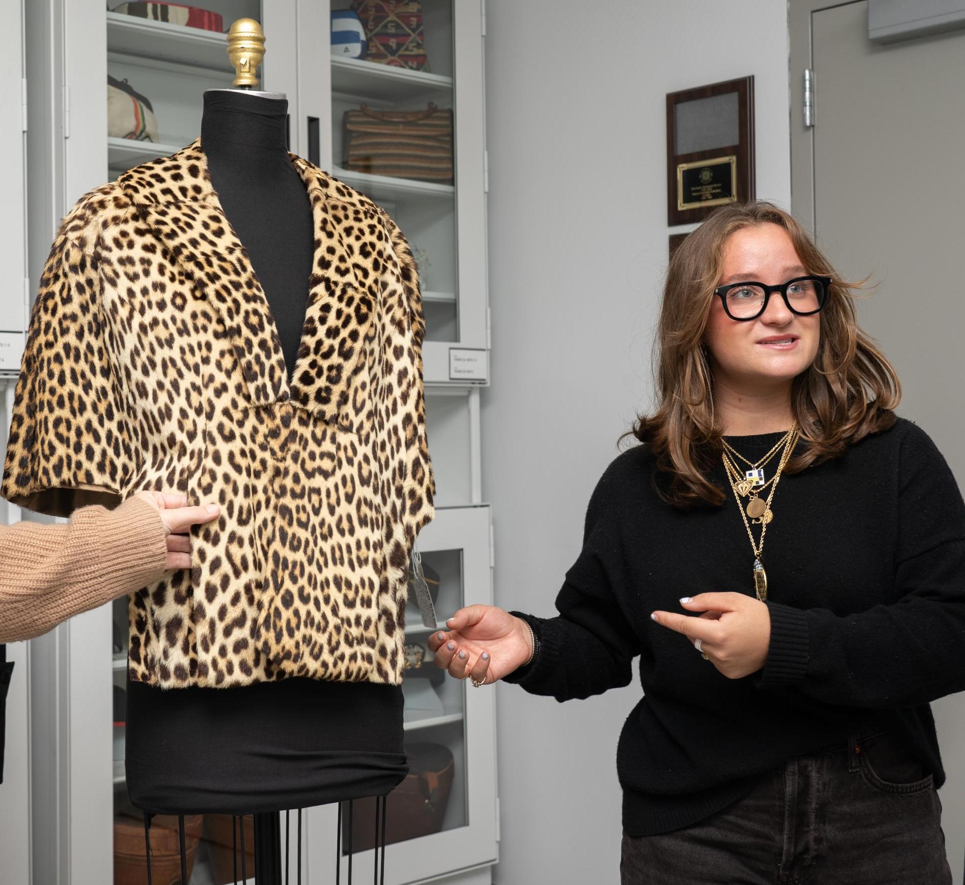 Sophia Peck points to a leopard print jacket