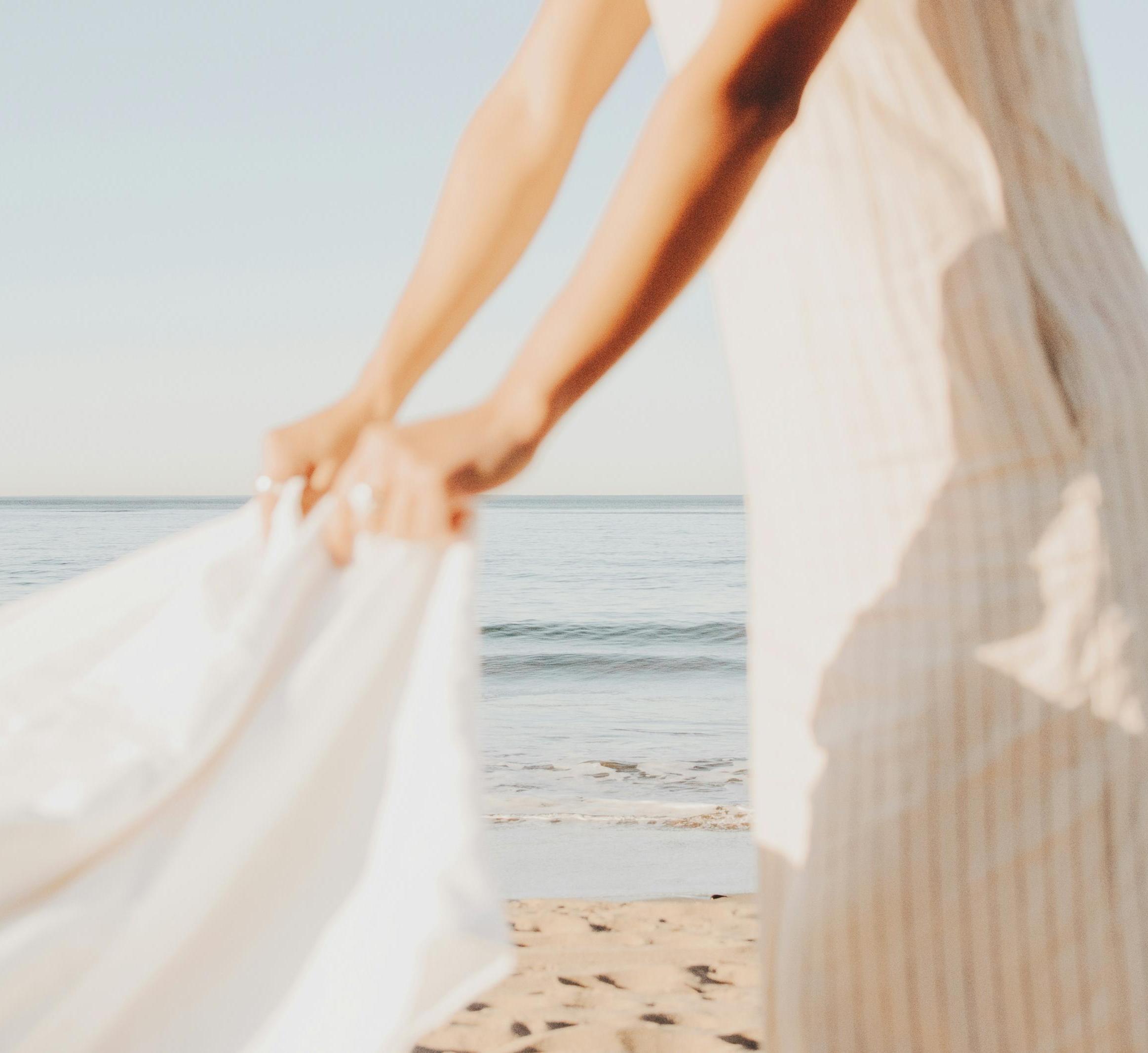a woman shakes out a white sheet