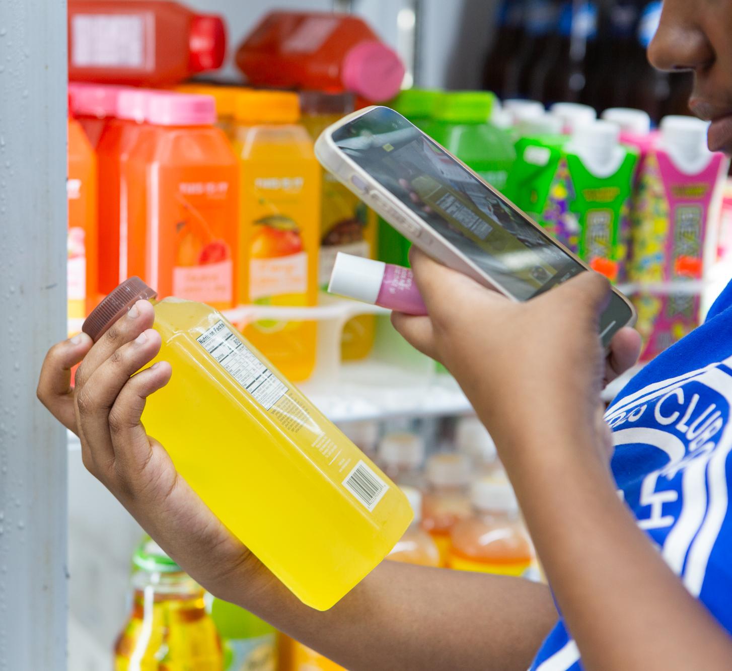 A person takes a photo of the label on a beverage 