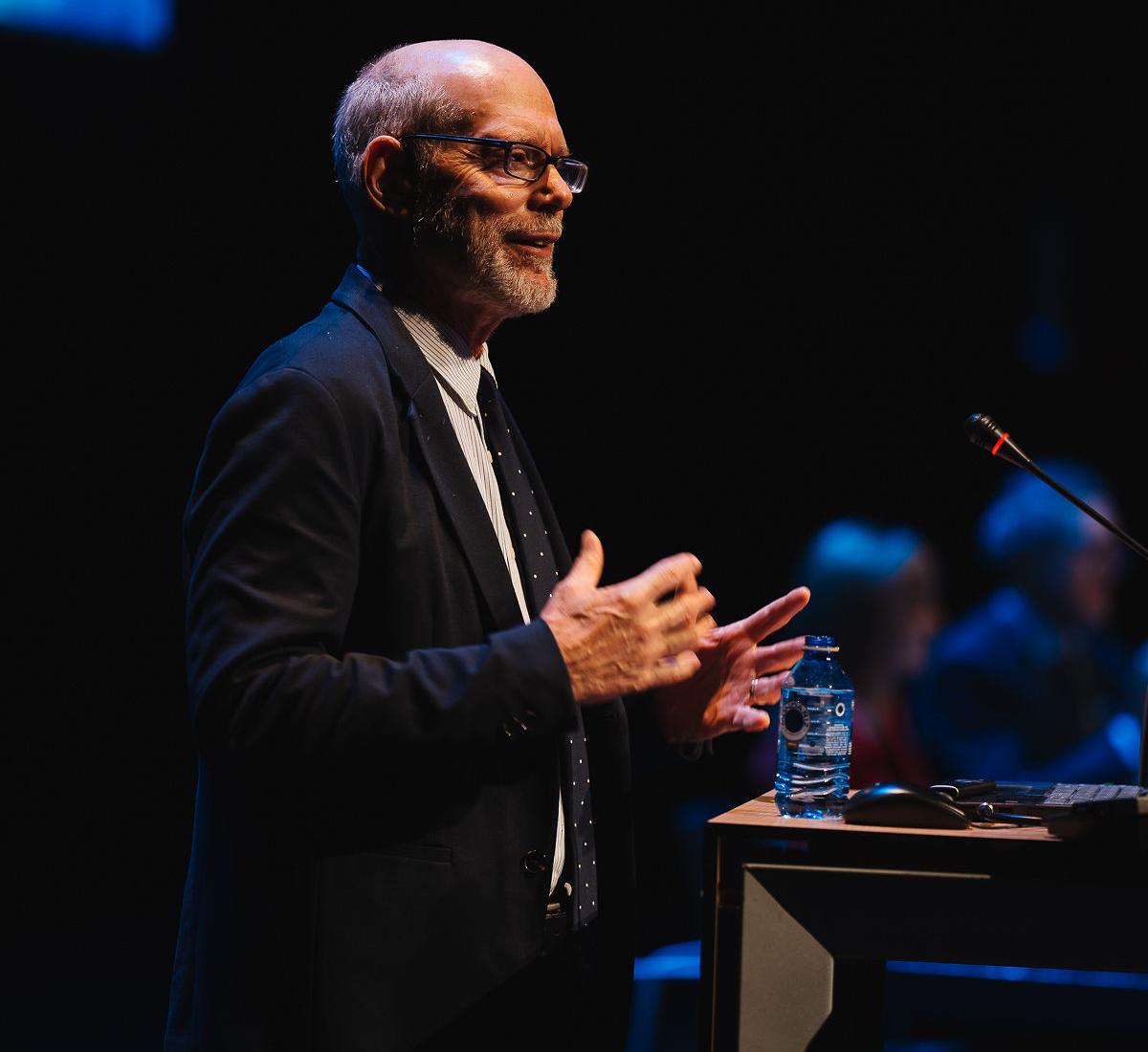Karl Pillemer speaks at a conference in front of a podium