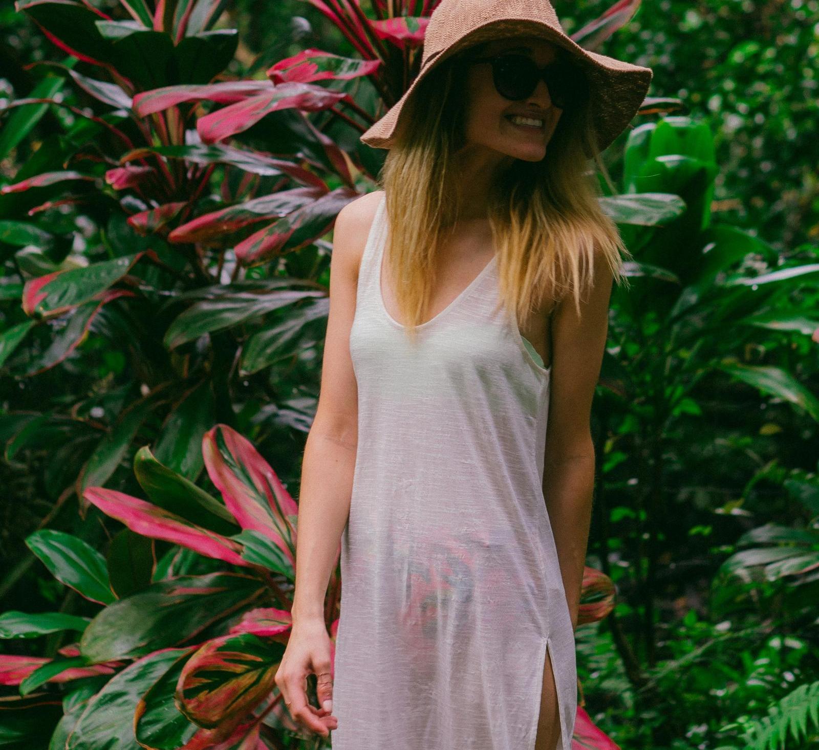 smiling woman in front of a plant in the daytime
