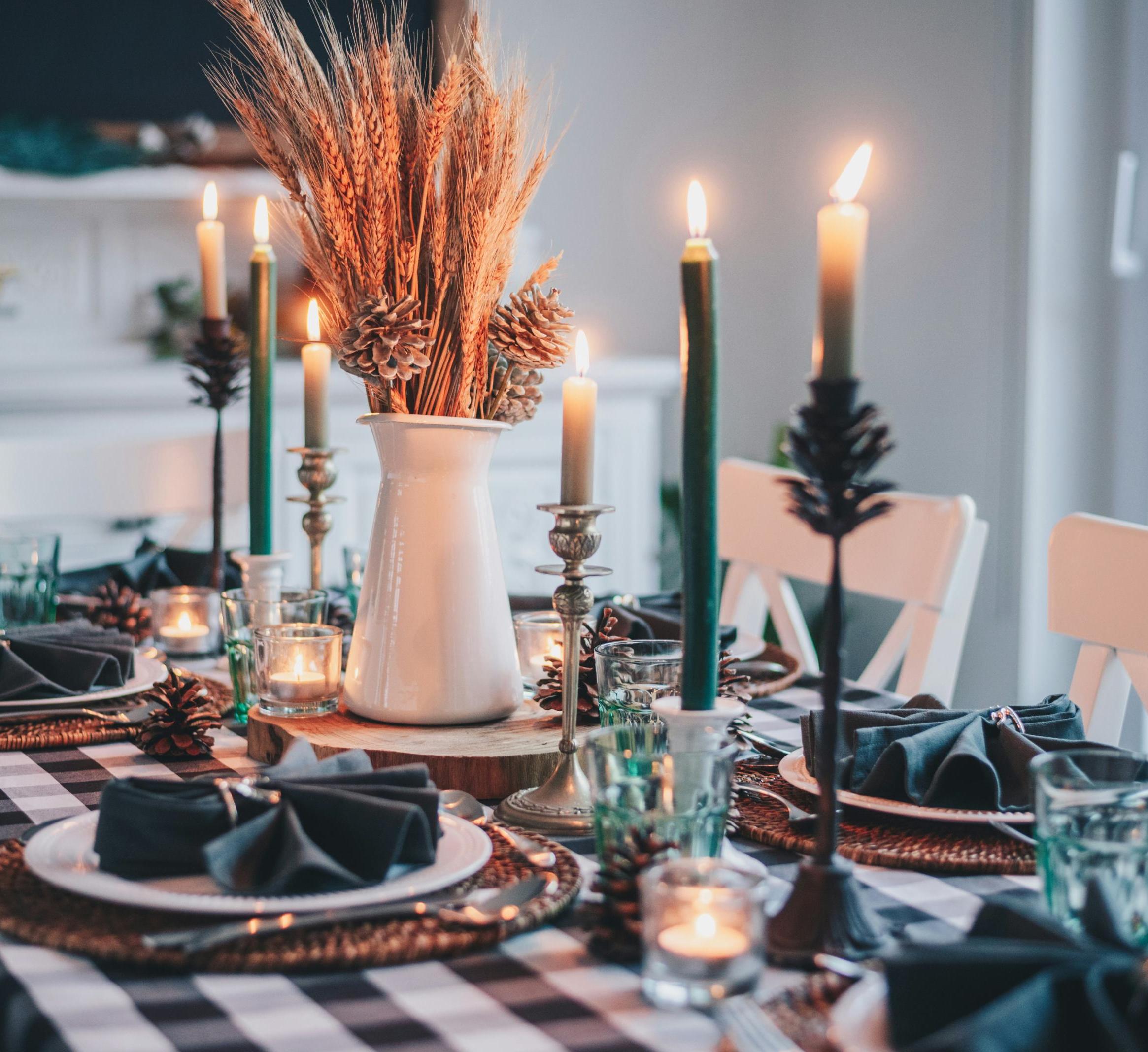 A table setting with candles and wheat