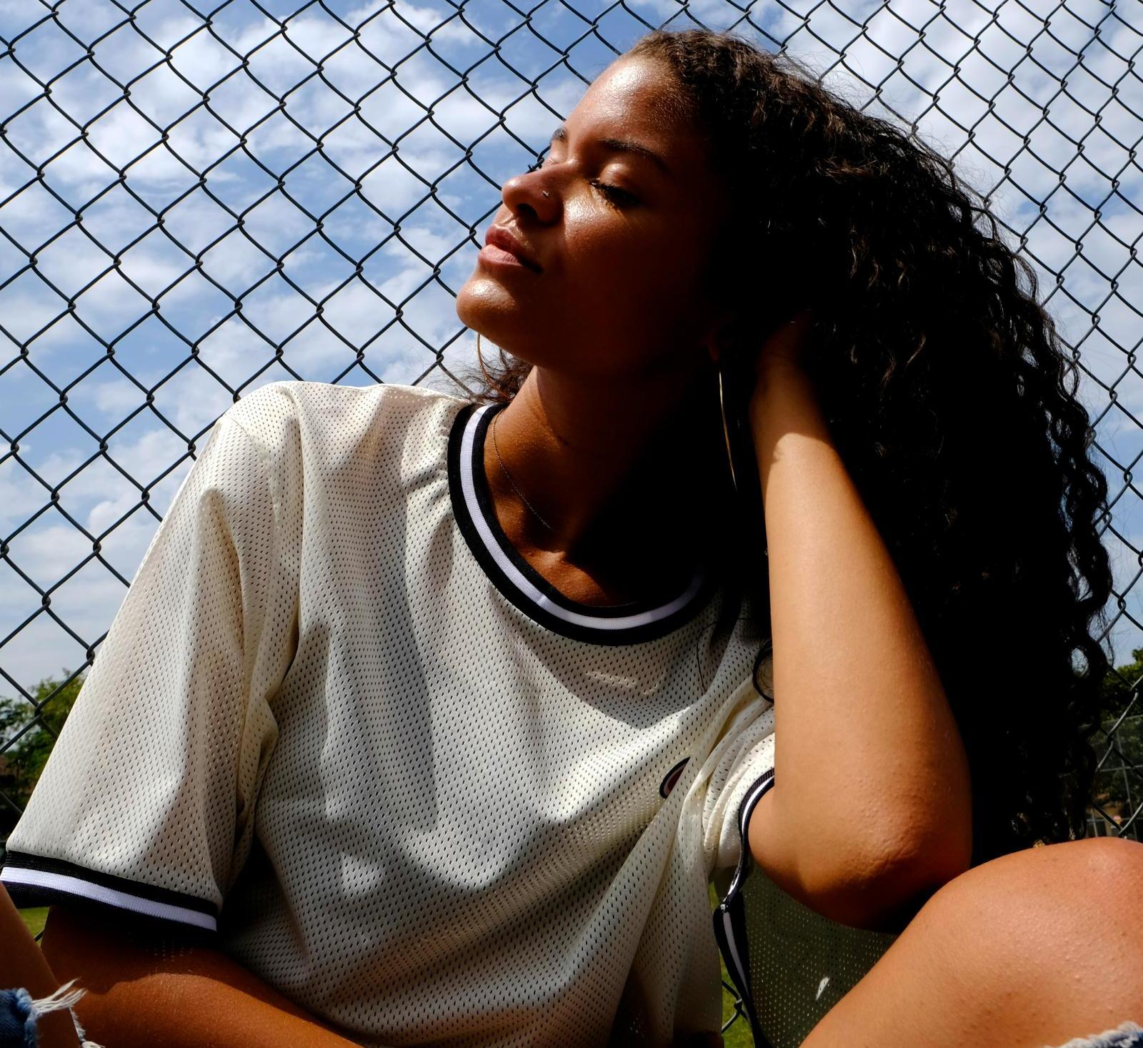 A person sits outside in the sun on a hot day