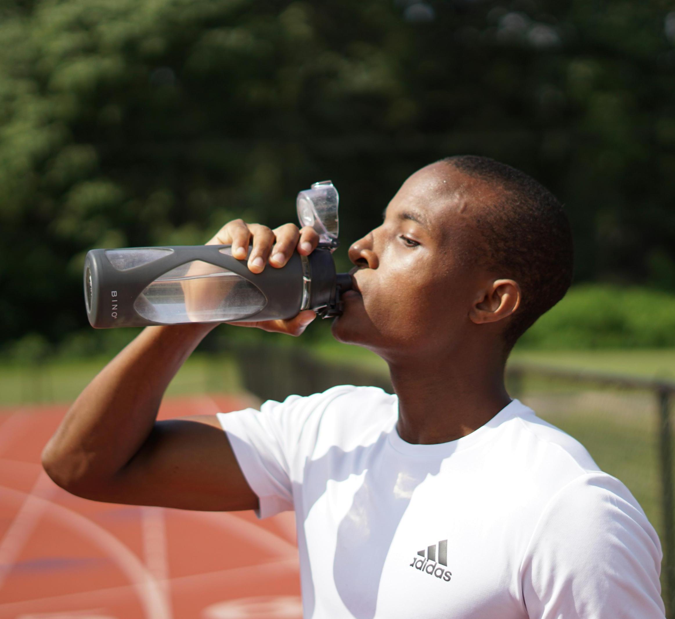 A person drinking from a water bottle in daytime