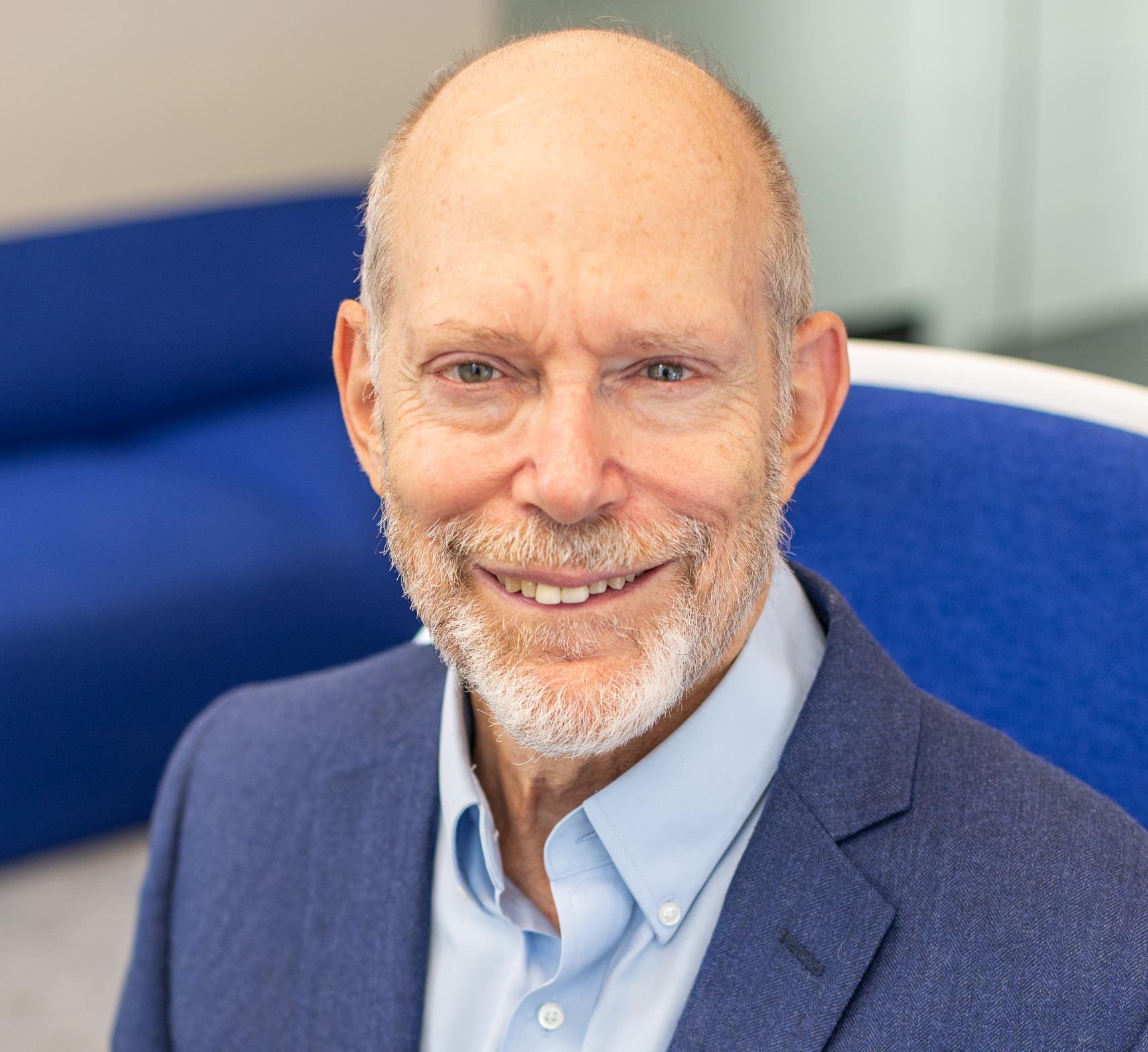 a man in a blue suit sitting in a blue chair