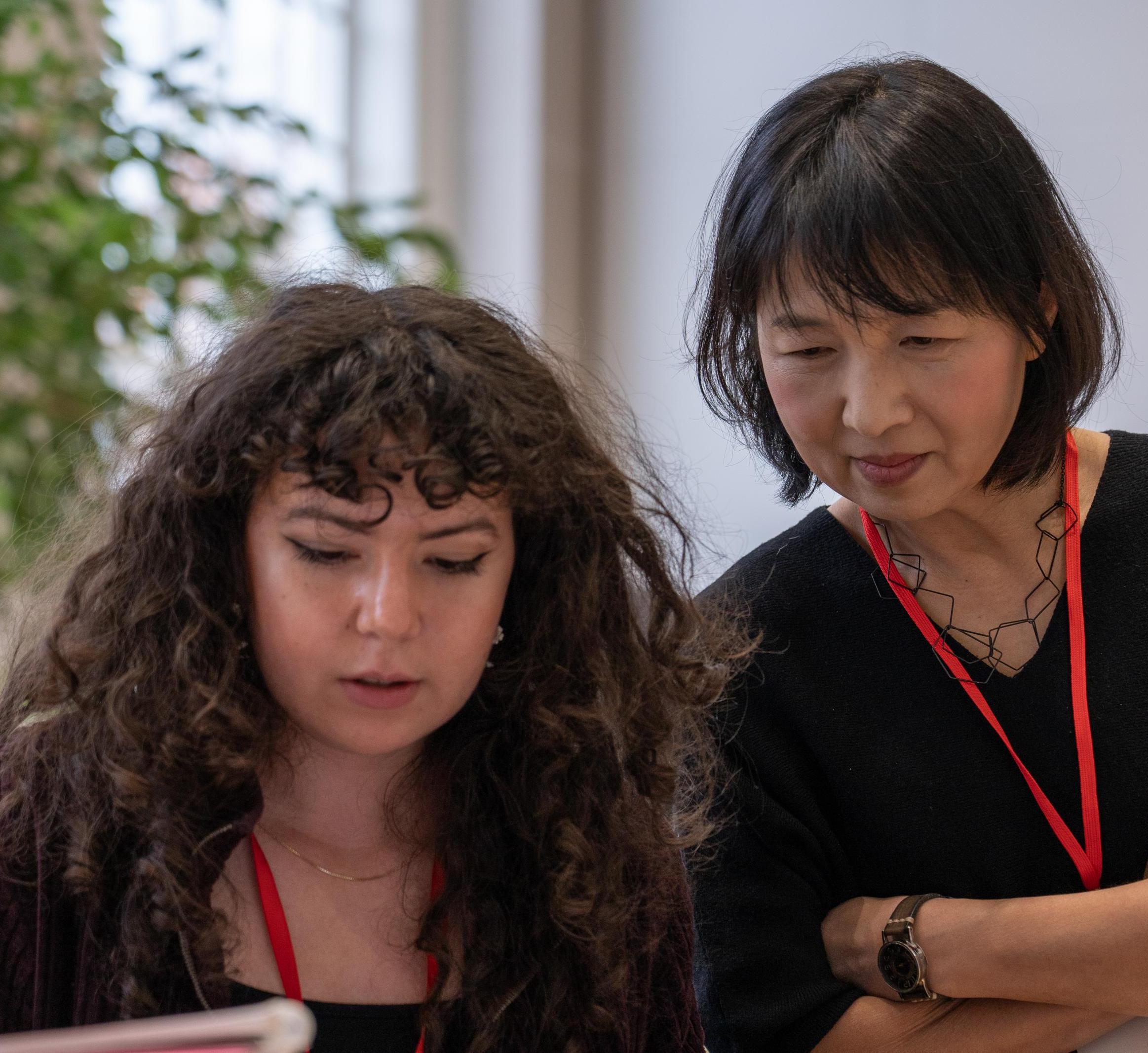 Prof. So-Yeon Yoon looks at a student's work 