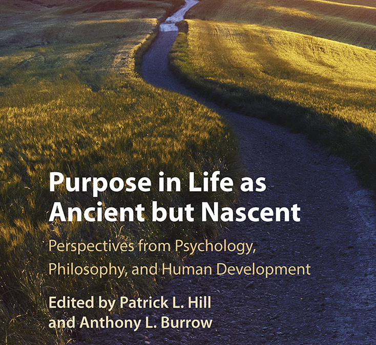 A cover of a book that is a winding road leading to a tree with mountains in the background