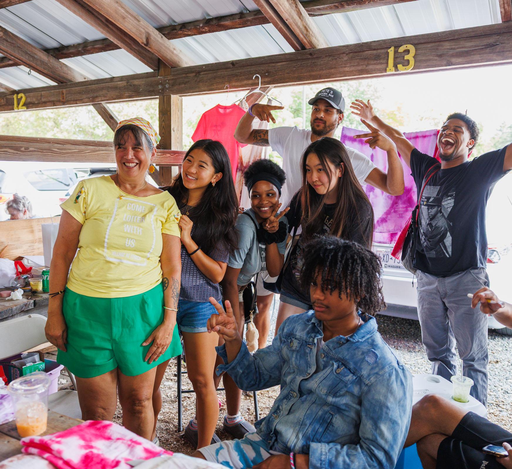 A group of students pose in a stand at a farmer's market