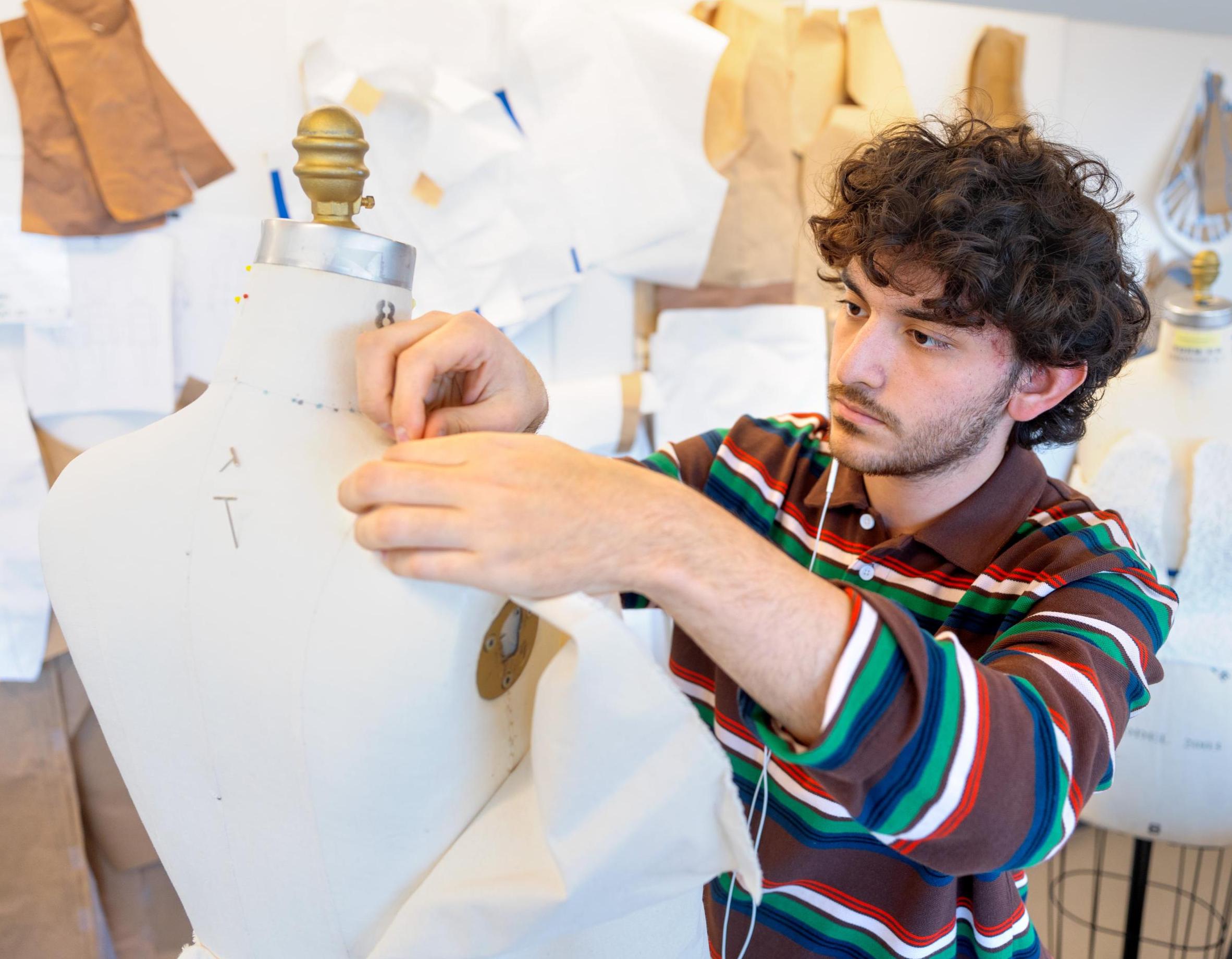 student pinning fabric to a mannequin