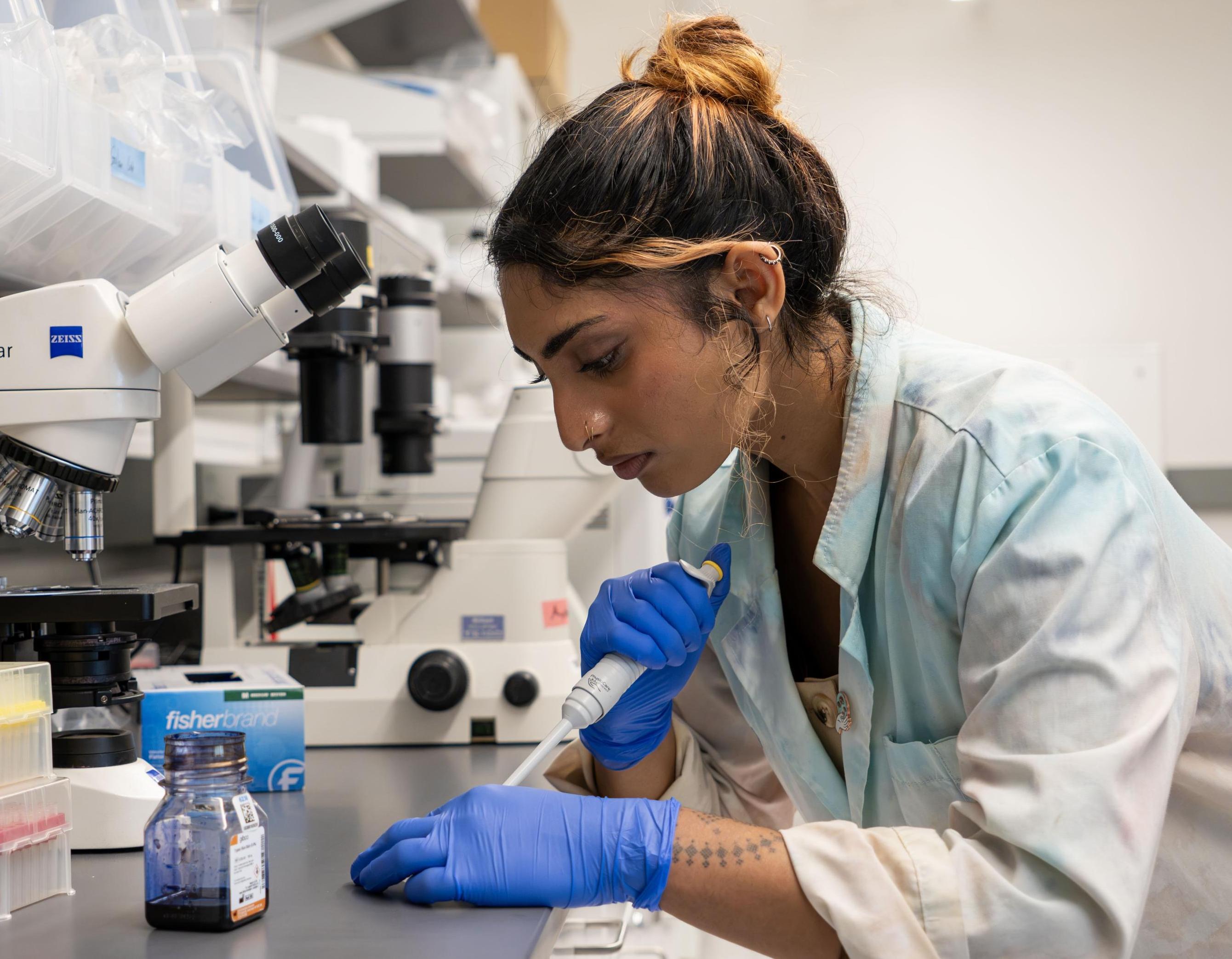 A student pipetting in the lab. 