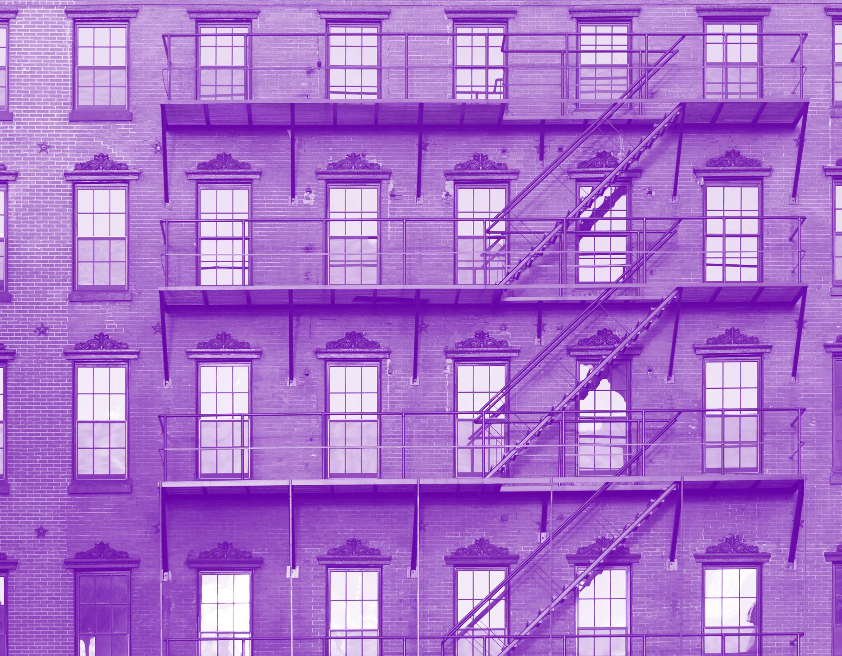 purple tinted image of the facade of a brick building