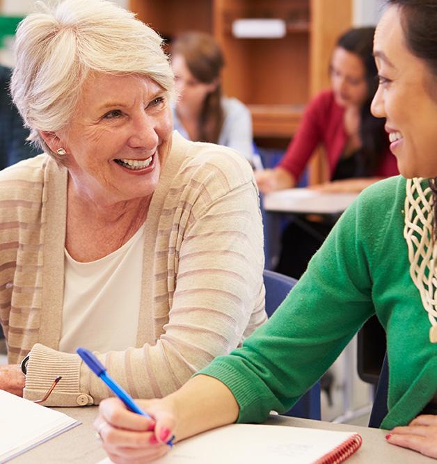 Adults attending class, with two students smiling at each other
