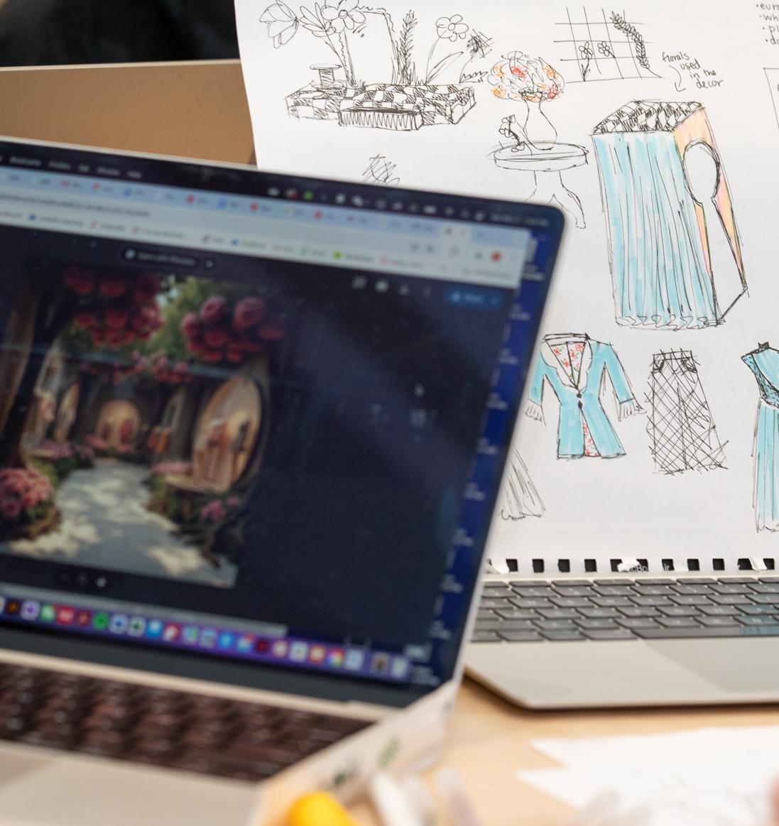 a computer screen with an illustration next to a book of fashion sketches