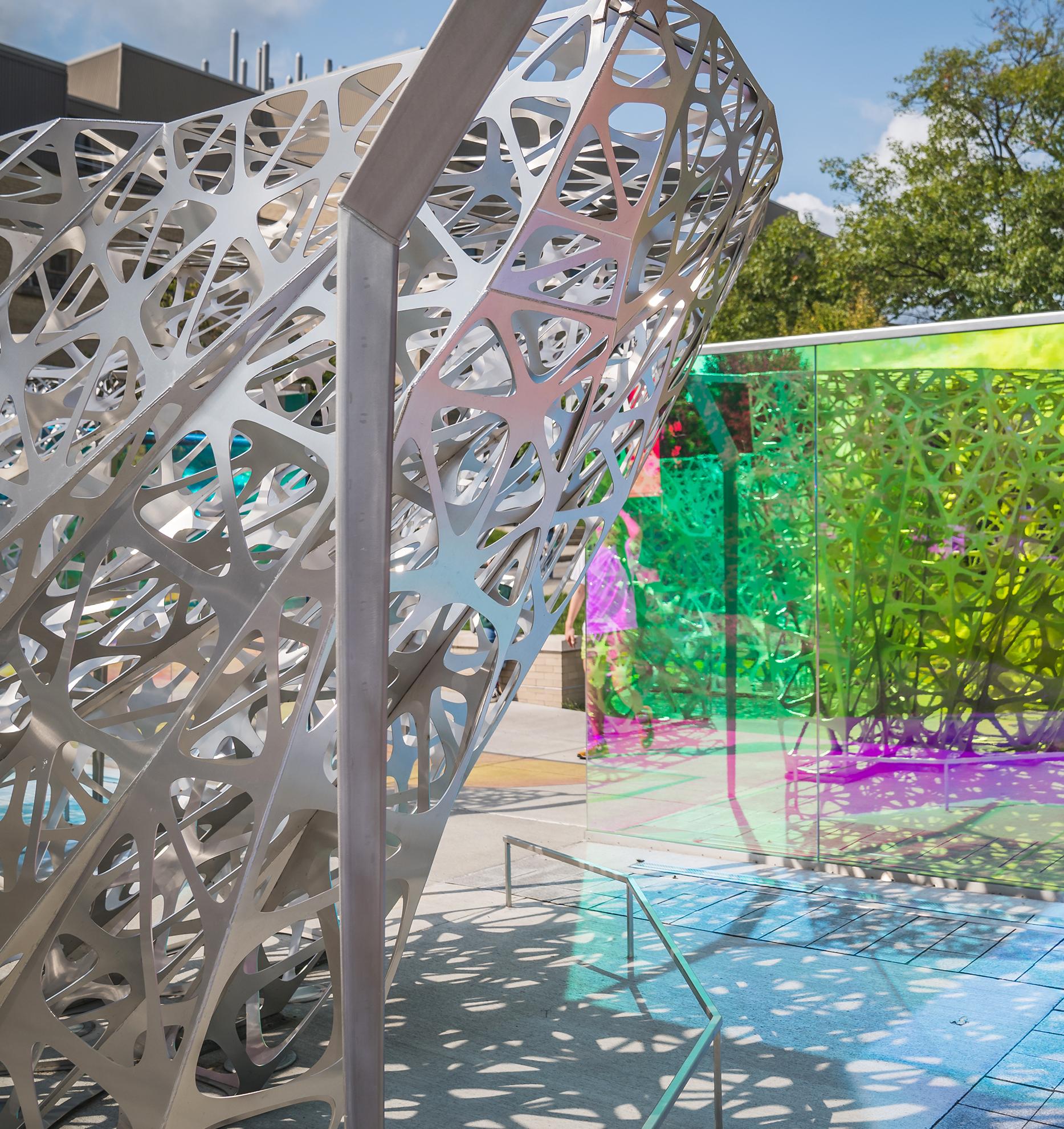 an abstract outdoor sculpture made of segmented metal and colored glass