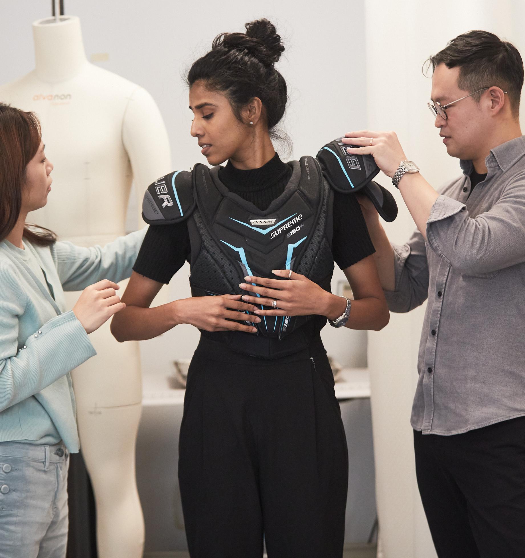 graduate students fitting protective gear onto a model