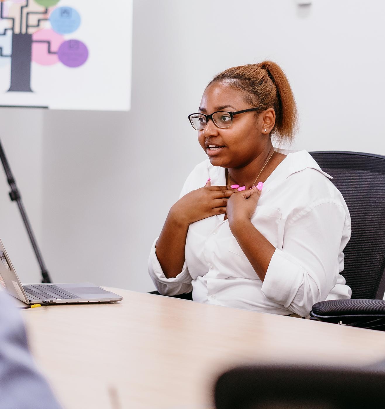 college student speaking at a conference table