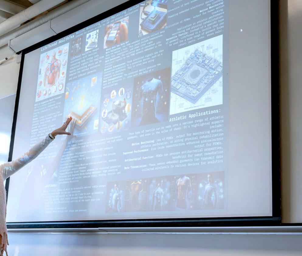 person with a microphone headset pointing at a screen showing a PPT