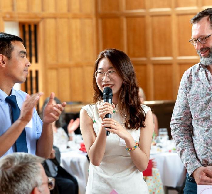 Two students and a faculty member stand together and present at the Merrill Scholar reception