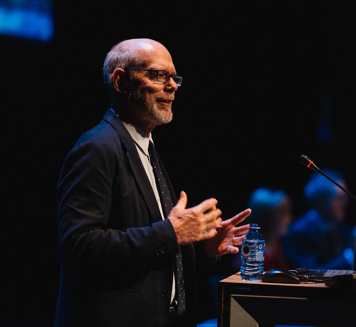 Karl Pillemer speaks at a conference in front of a podium