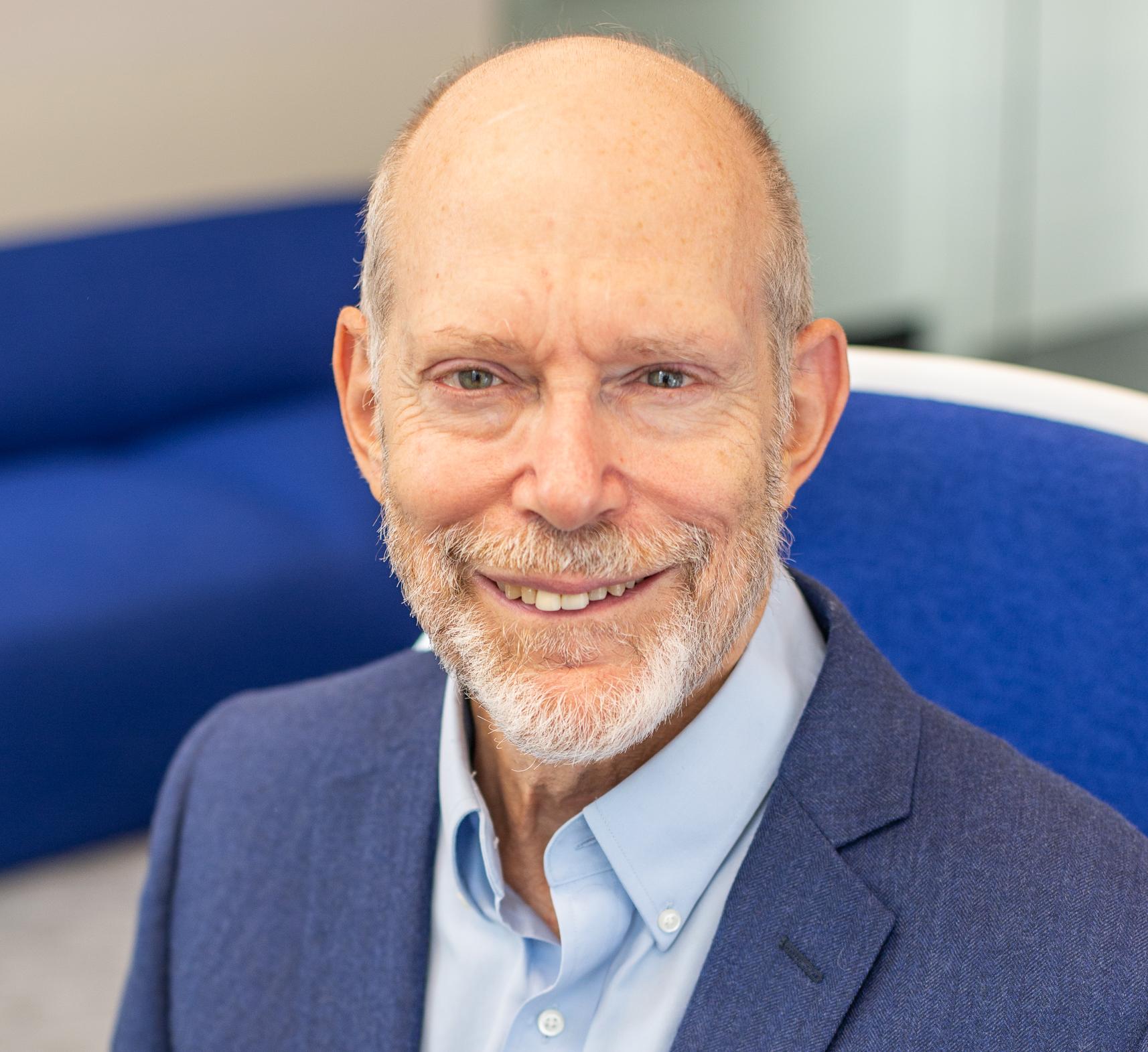 a man in a blue suit sitting in a blue chair