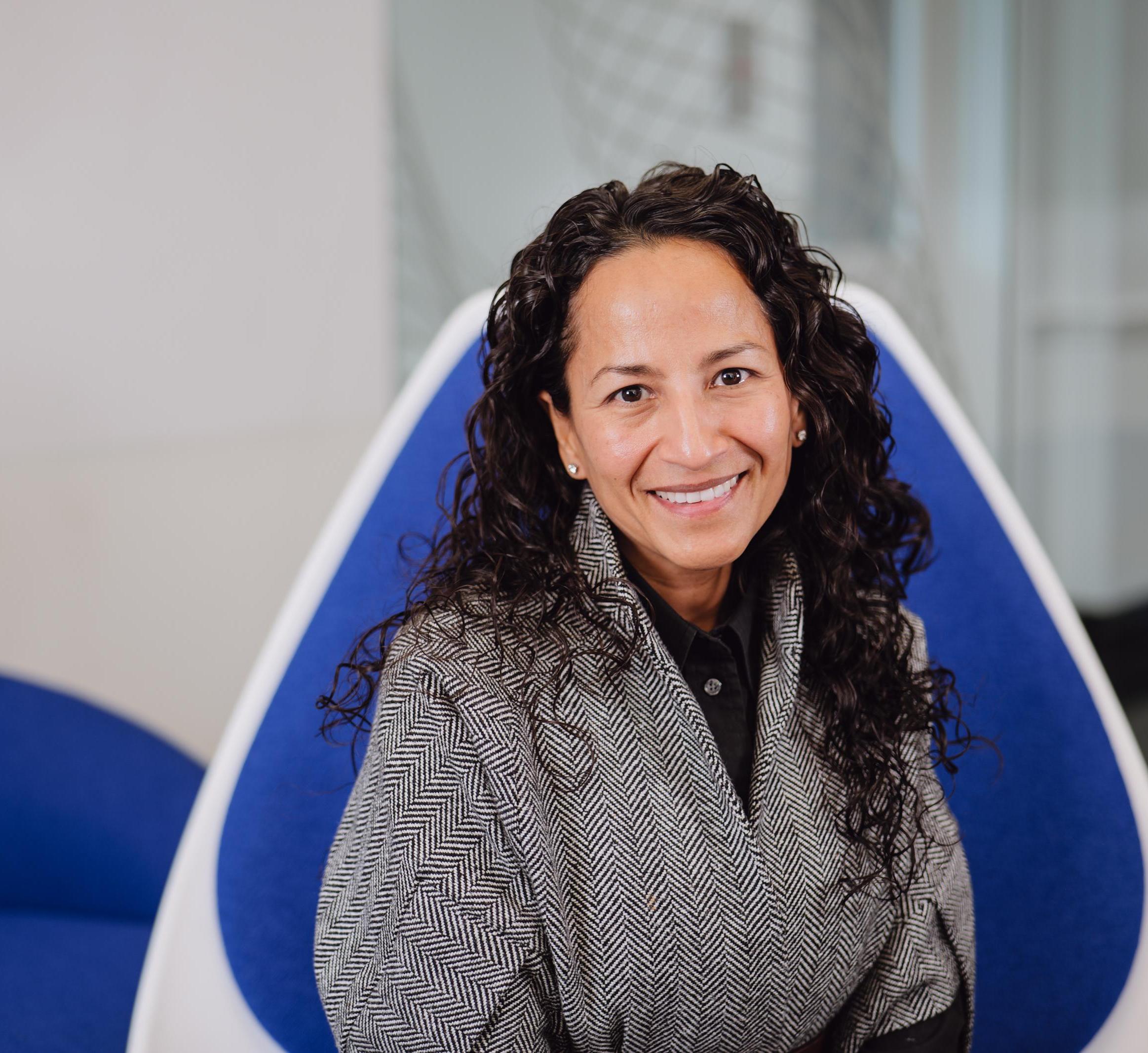 Portrait of Marla Lujan sitting in a blue chair