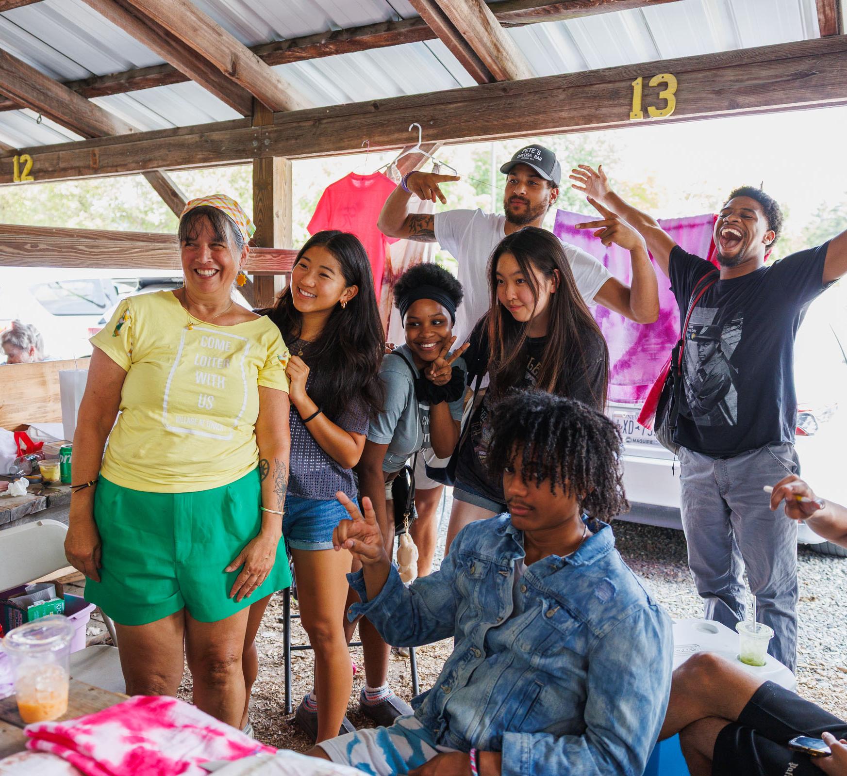 A group of students pose in a stand at a farmer's market
