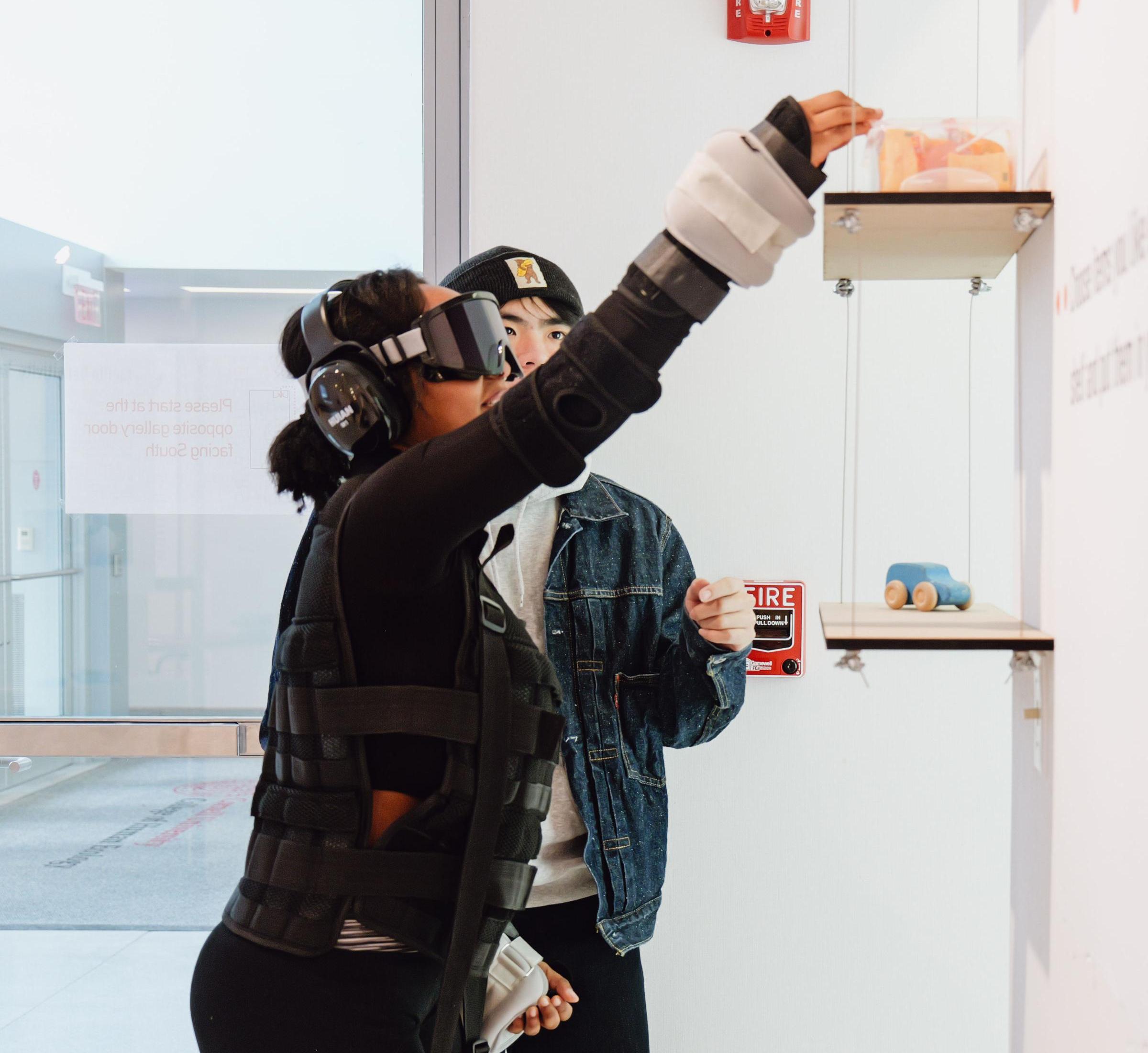 A participant reaching for an item on a shelf in the exhibit 