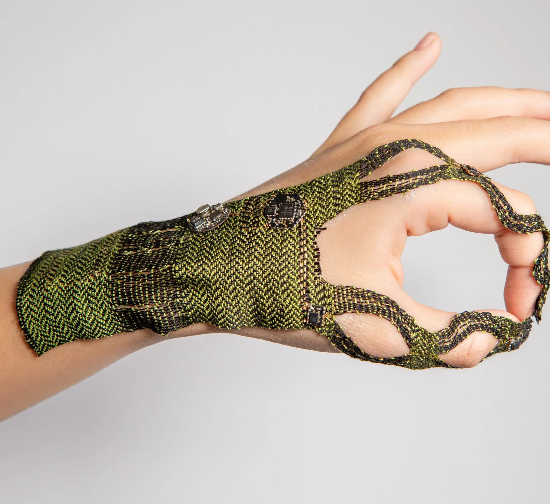 A hand with green woven textile on it.