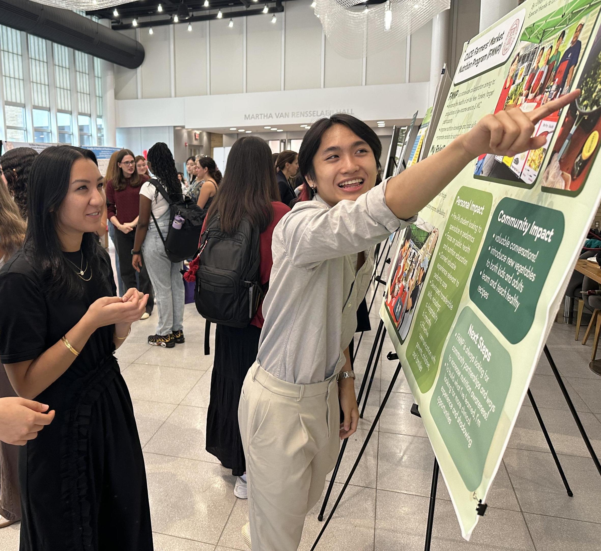 student pointing at poster while others look on