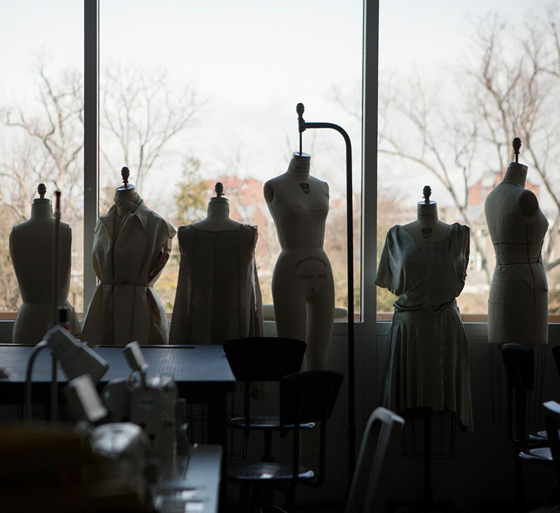 silhouetted row of mannequins against a wall of windows