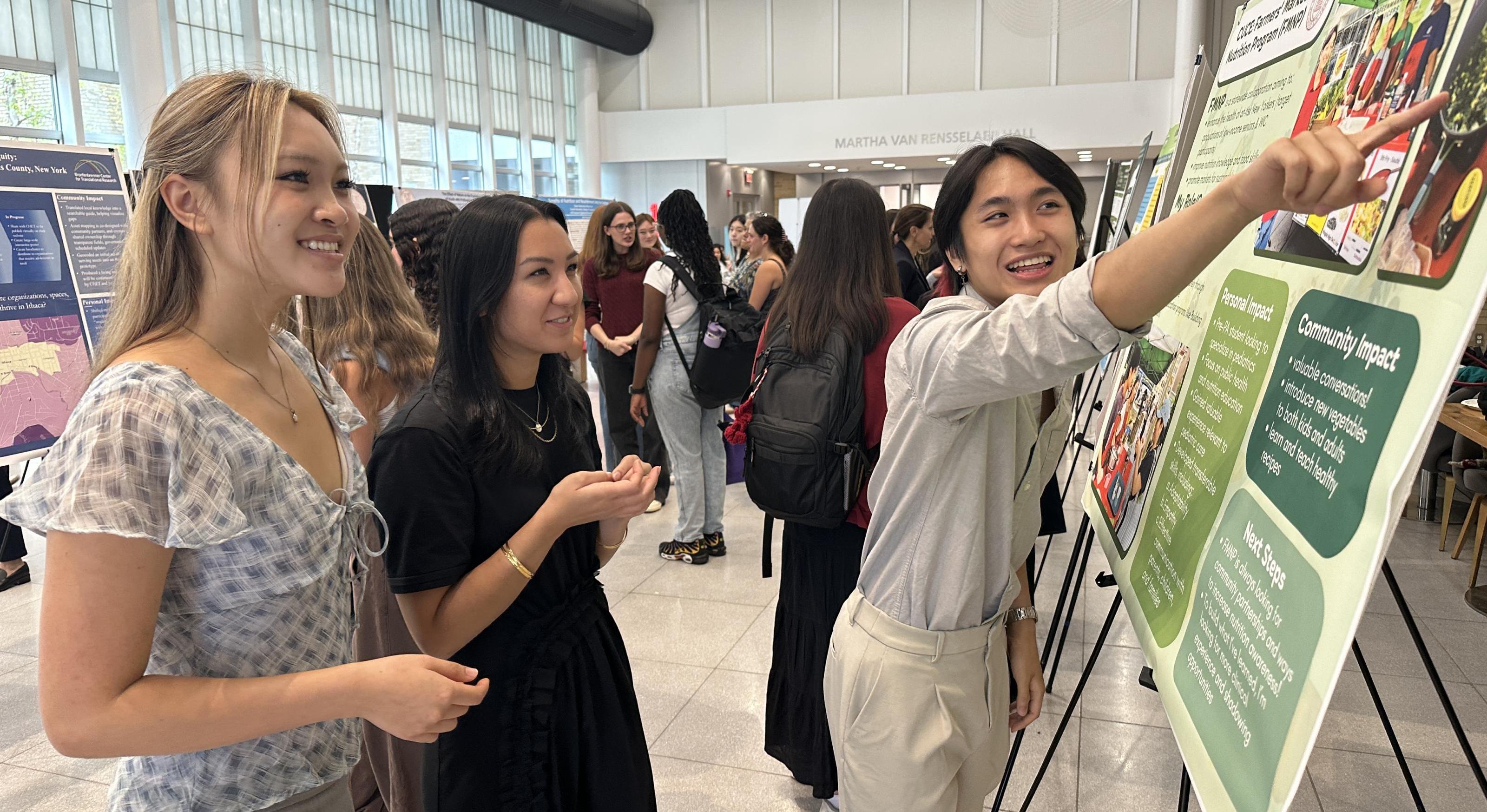 student pointing at poster while others look on