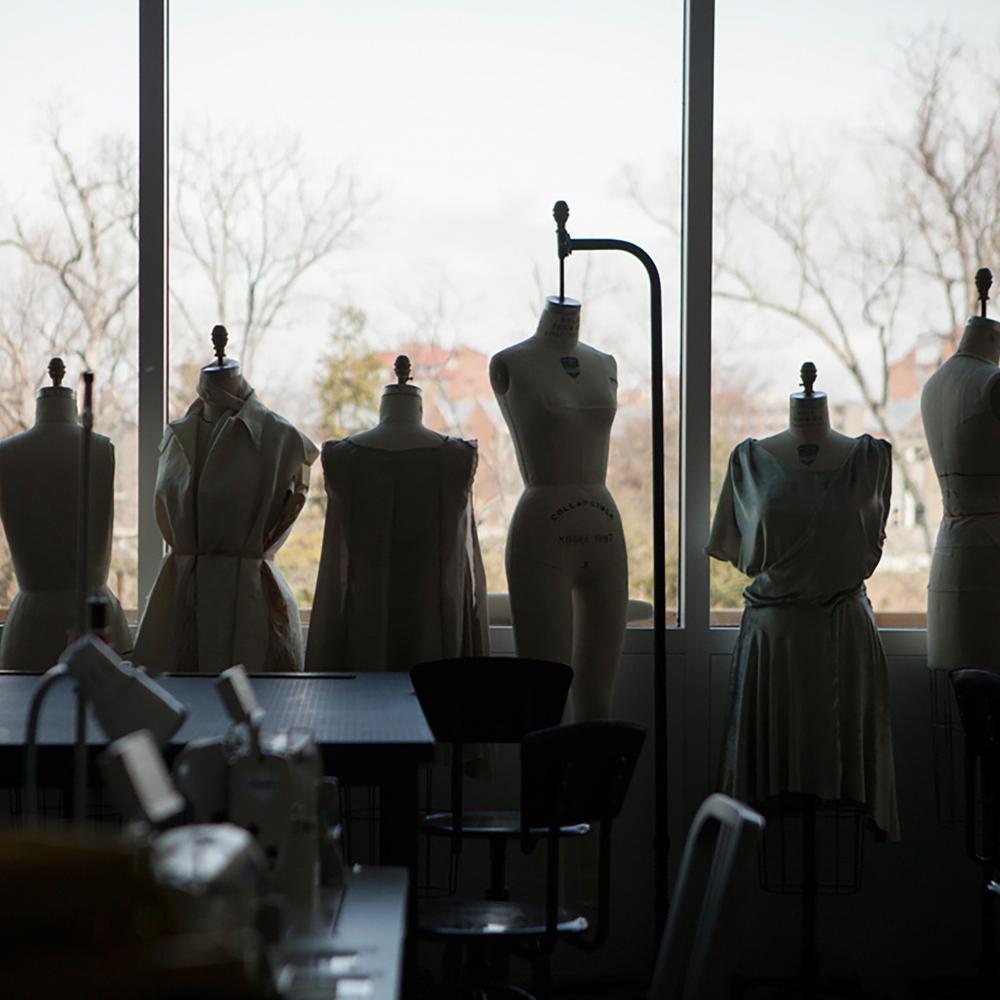 silhouetted row of mannequins against a wall of windows
