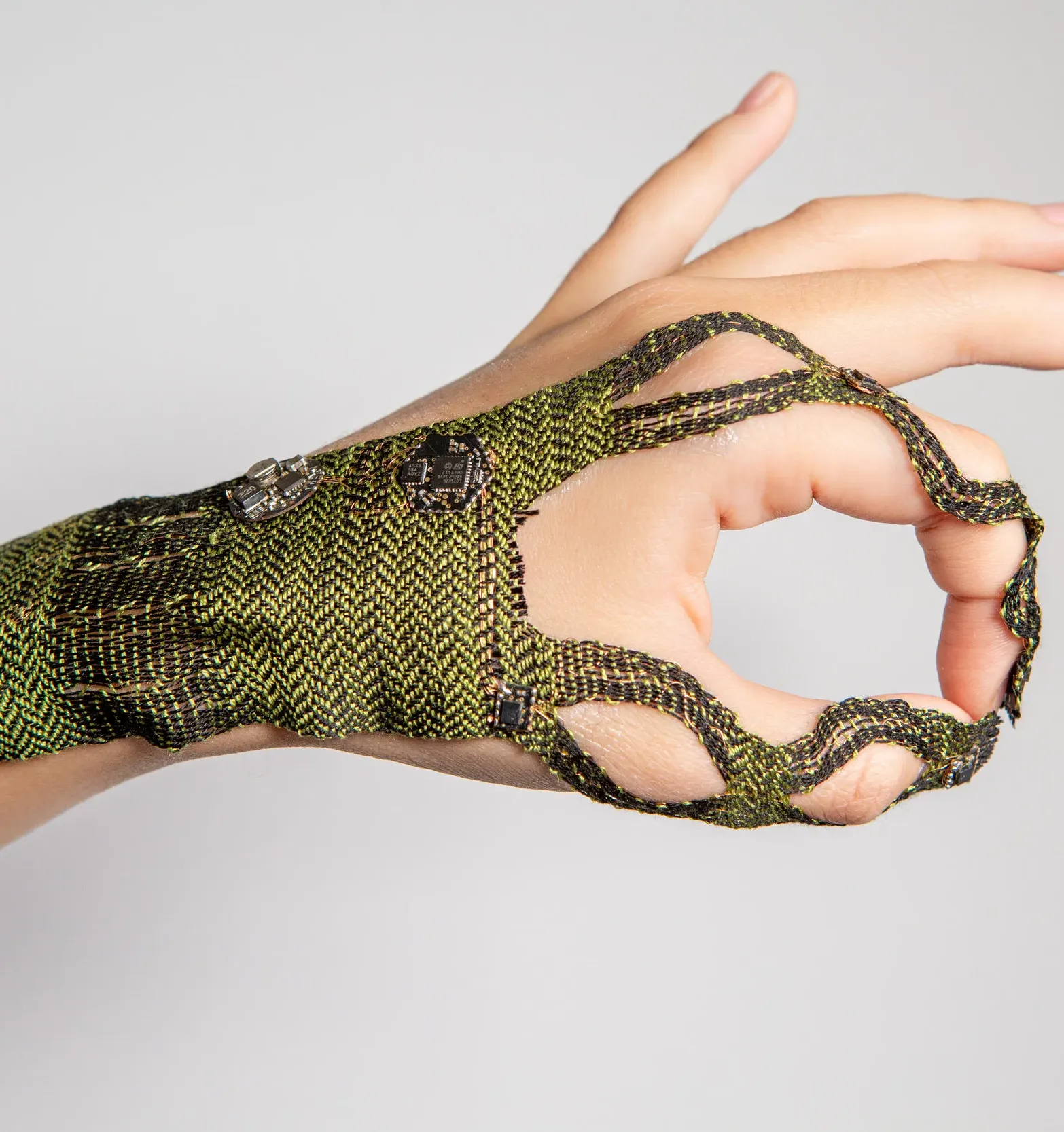 A hand with green woven textile on it.