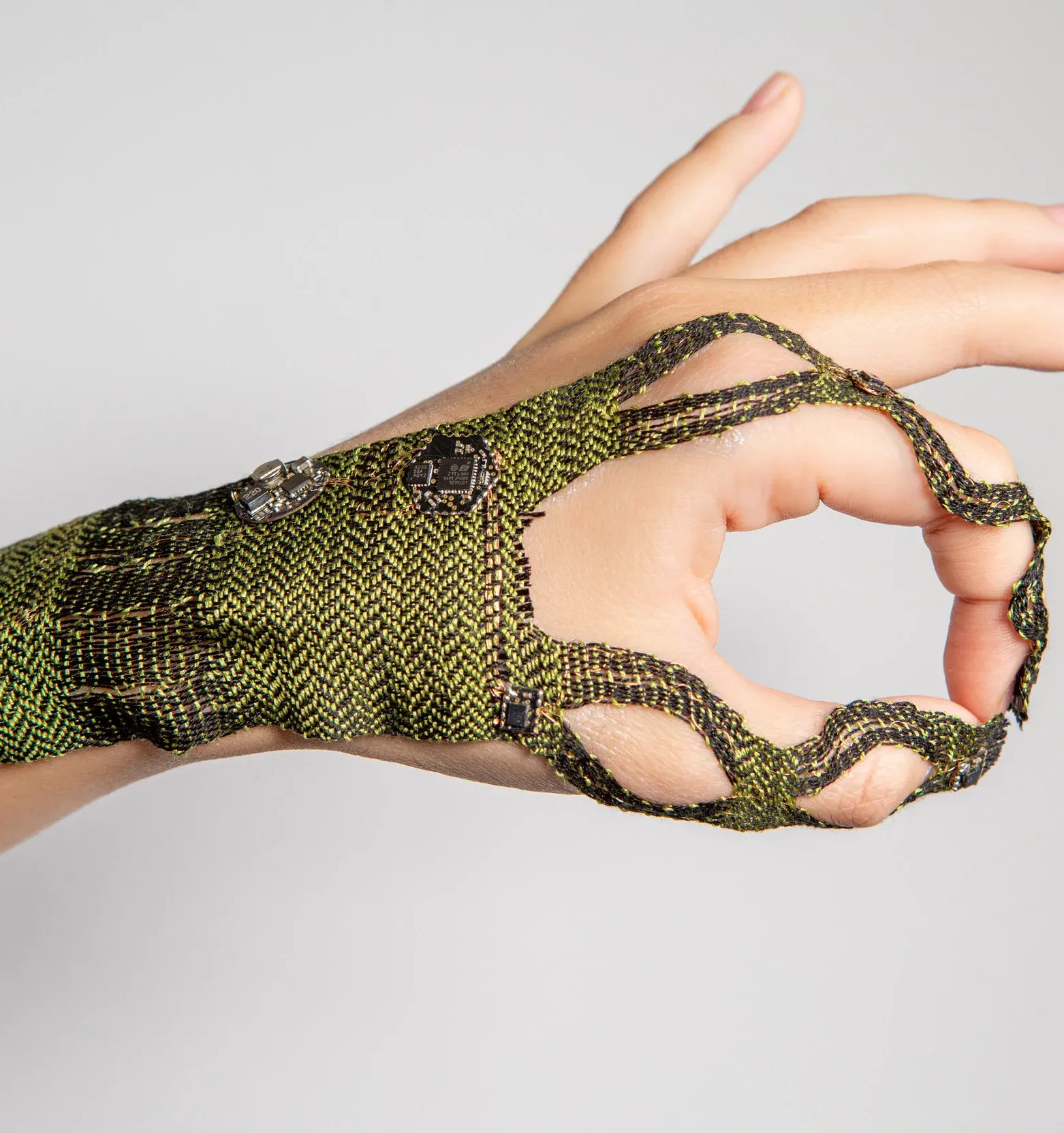 A hand with green woven textile on it.